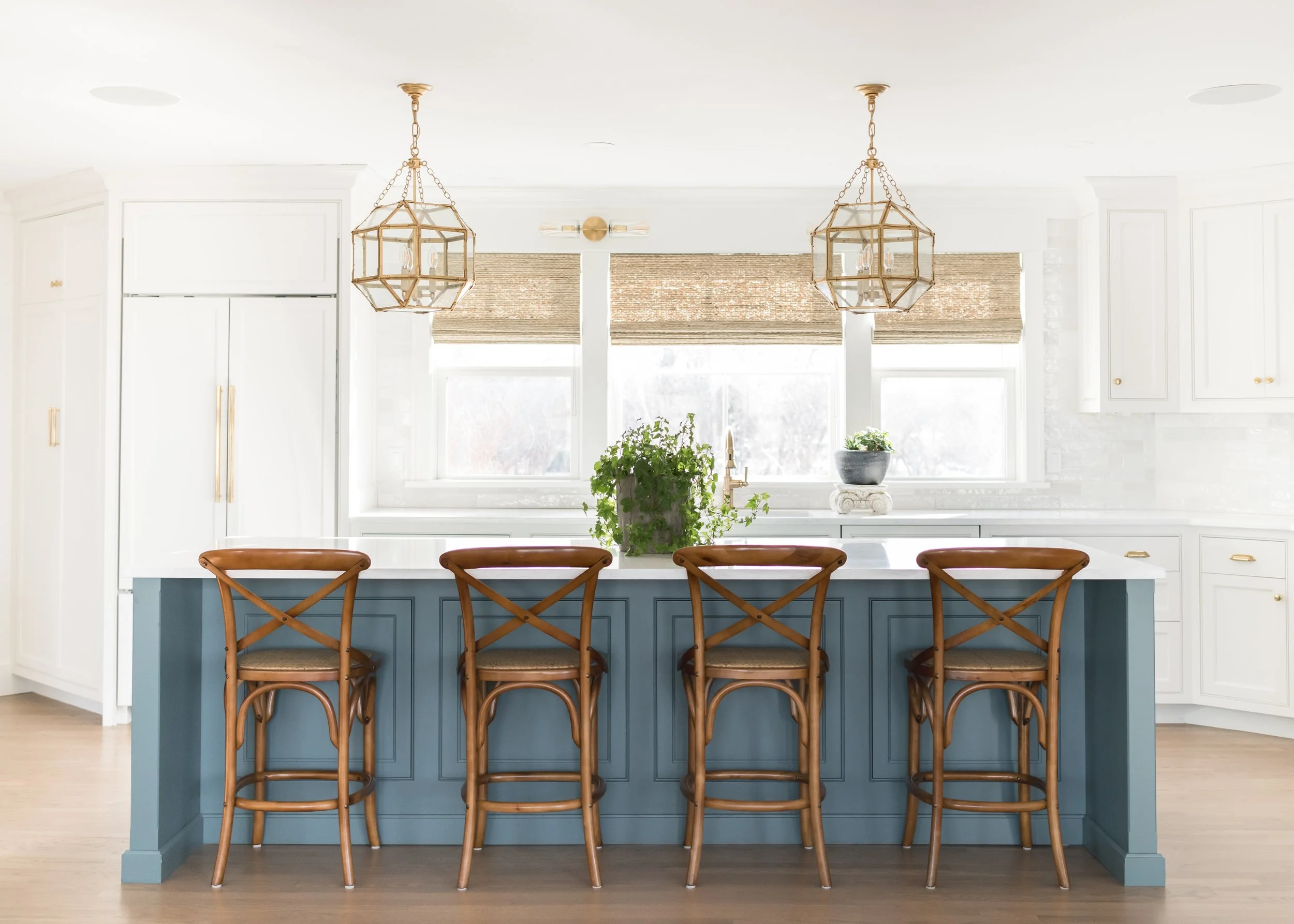 Navy kitchen island with cross-back stools and brass lantern pendants at Labor in Vain, Ipswich, MA, designed by IvoNavy kitchen island with rush-seat stools and brass lantern pendants at Labor in Vain, Ipswich, MA, designed by Ivory & Bone Interiors