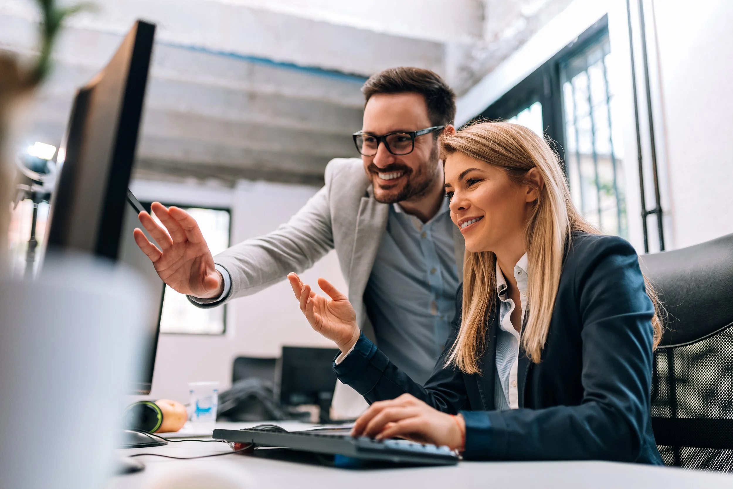Two young business colleagues working on computer