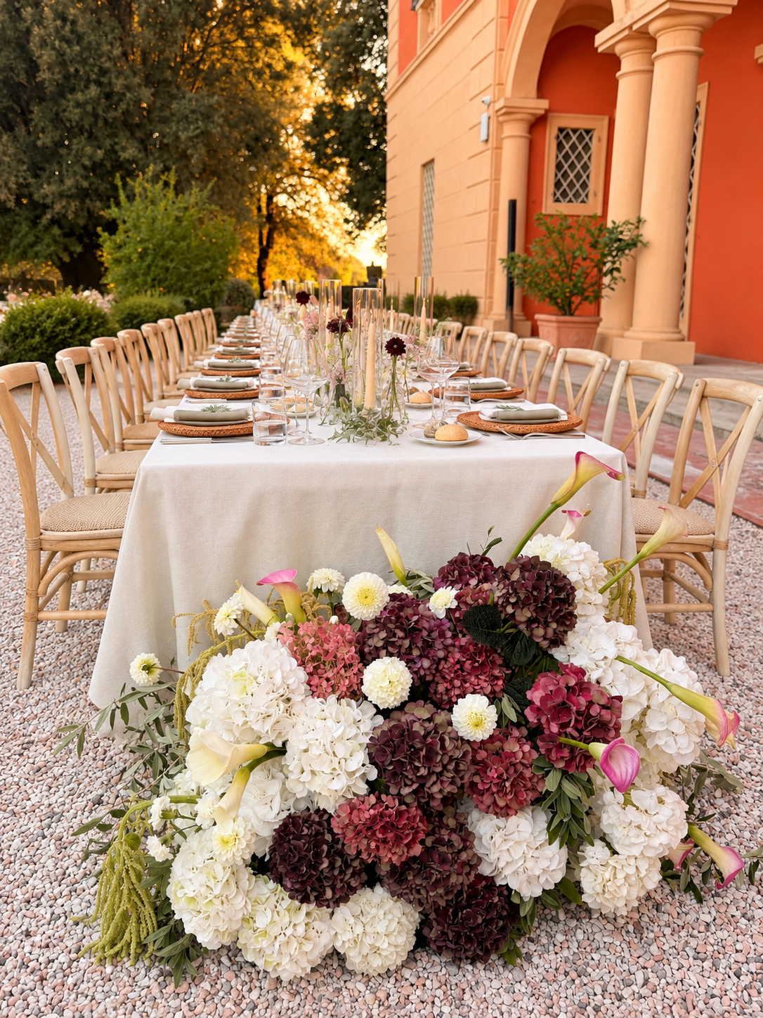 Blumenarrangement vor gedeckter Tafel und Villa.png