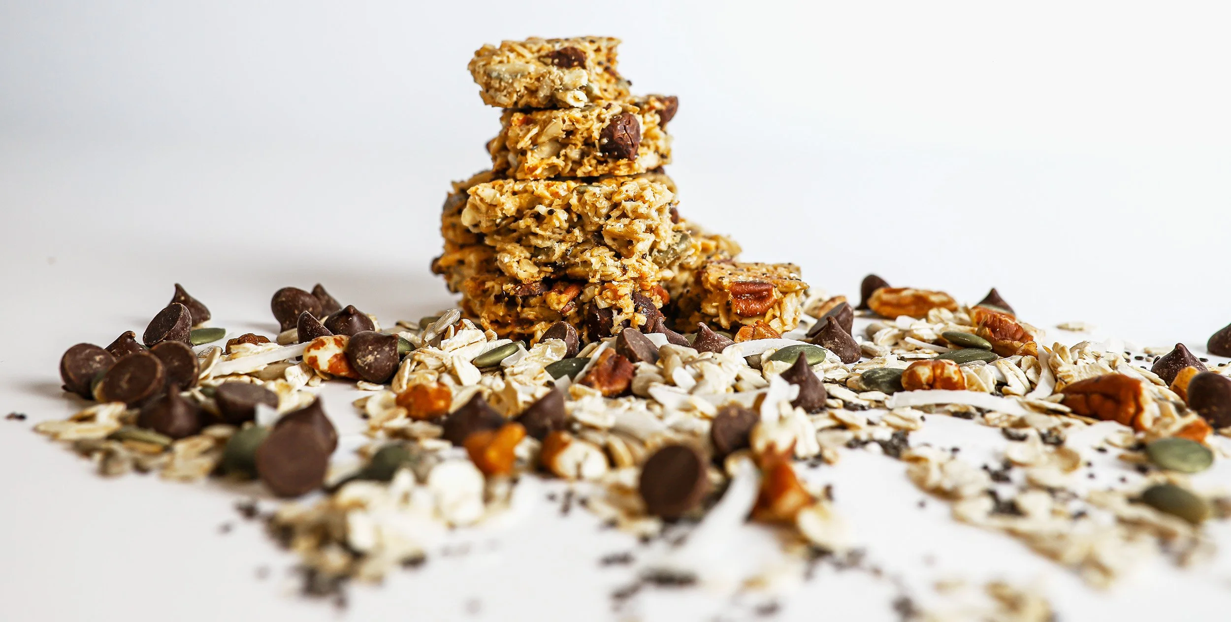 stack of granola bites surrounded by a scattering of loose ingredients