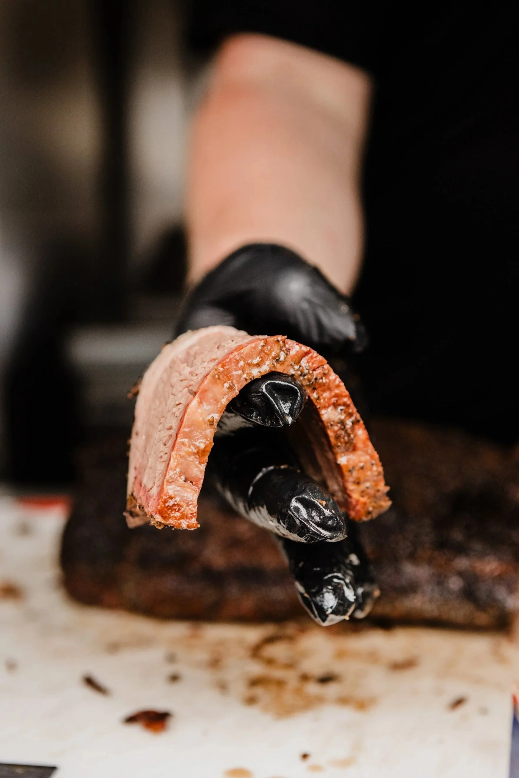 Close-up of a Texas-style brisket slice showing the smoke ring and peppery bark