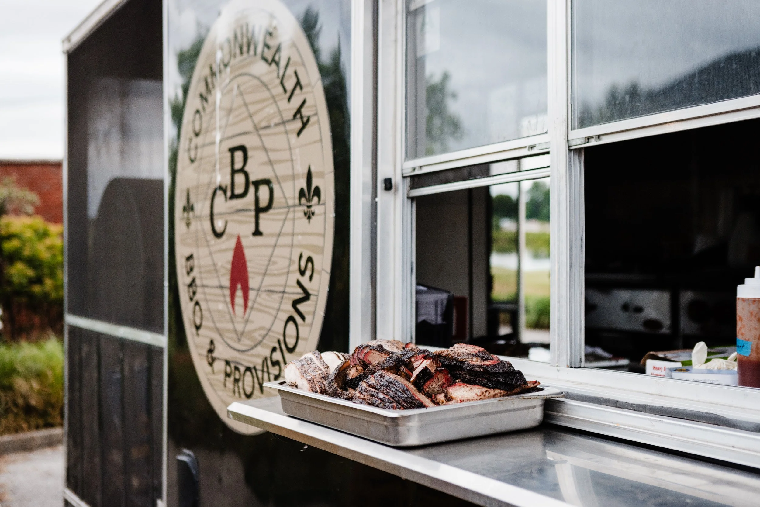 Commonwealth BBQ and Provisions food truck with a tray of smoked meats placed on the serving counter.