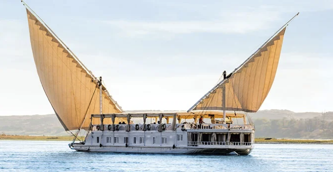 A boat with large, raised, sail-like wooden panels on the sides, sailing on a body of water.