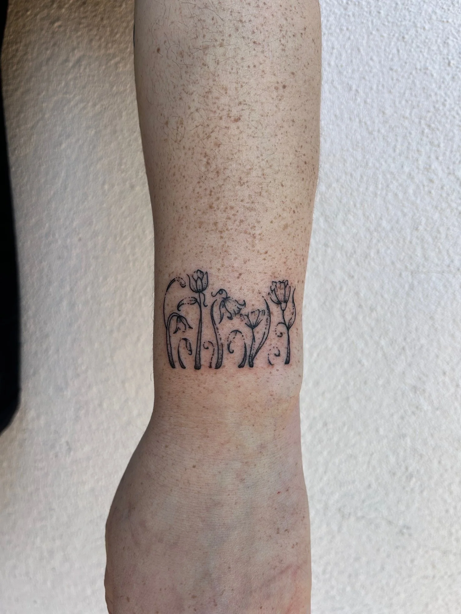 Fine line flower tattoo by Jeff Beck