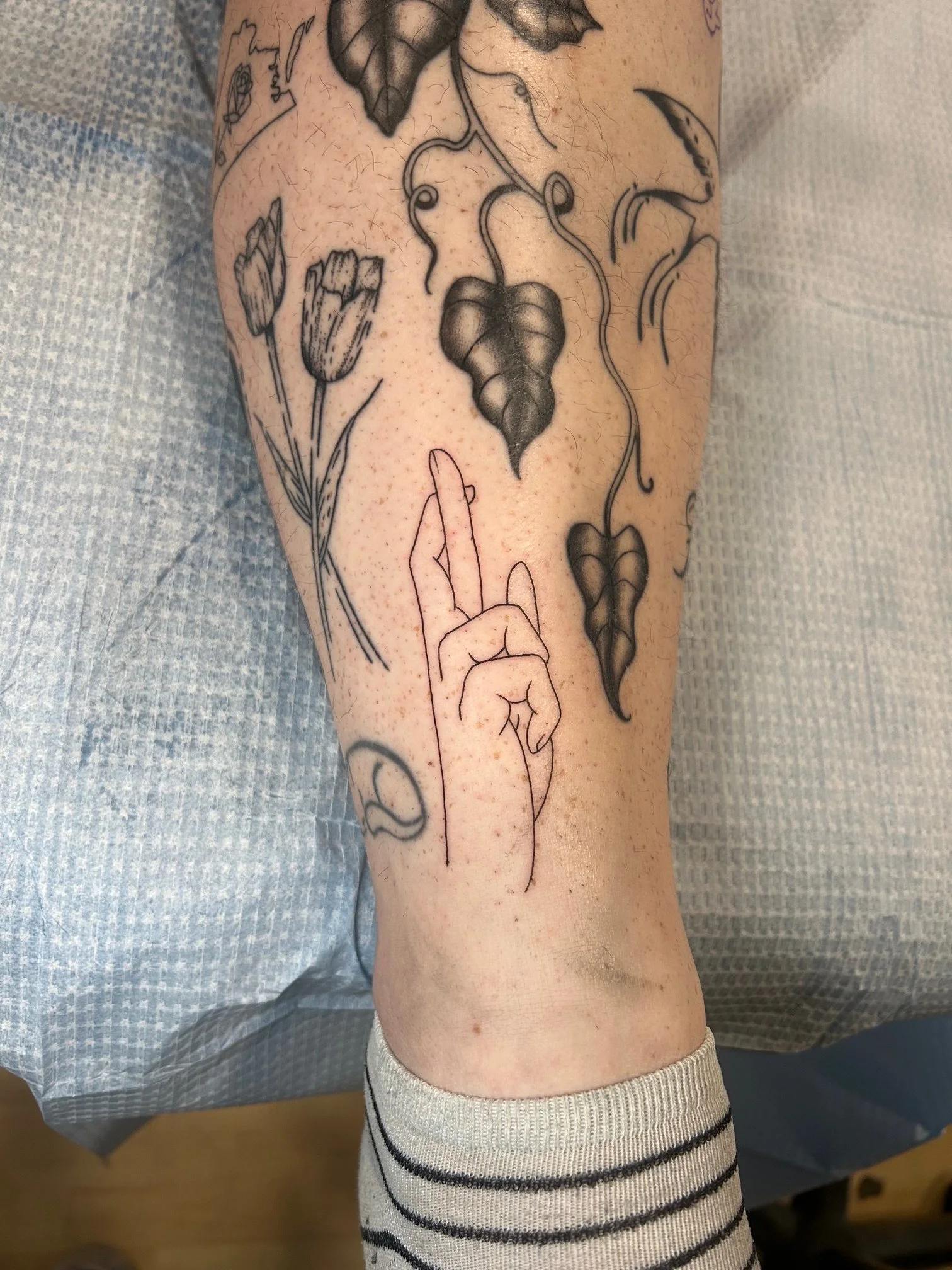 Crossed fingers fine line tattoo by Nicole Cosner