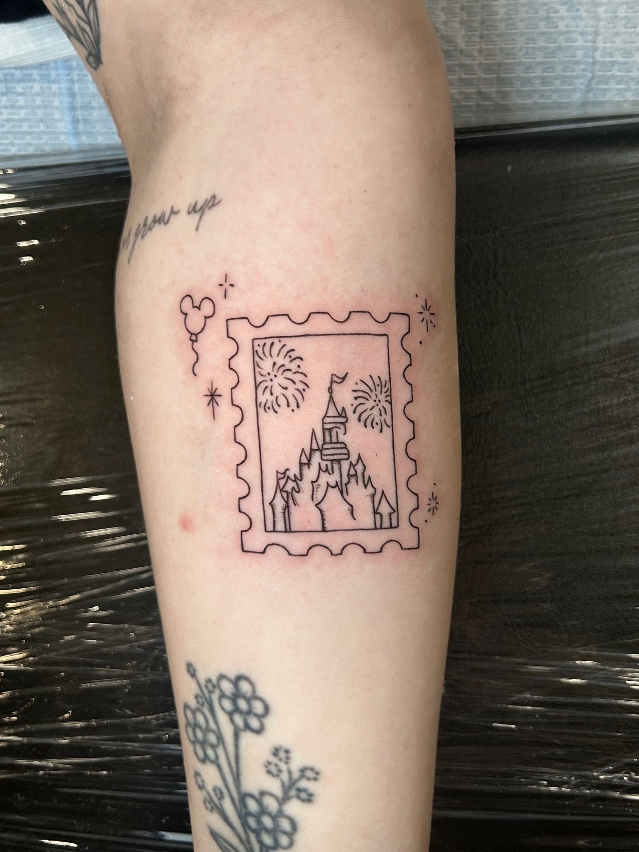 fine line Disney stamp tattoo by Nicole Cosner