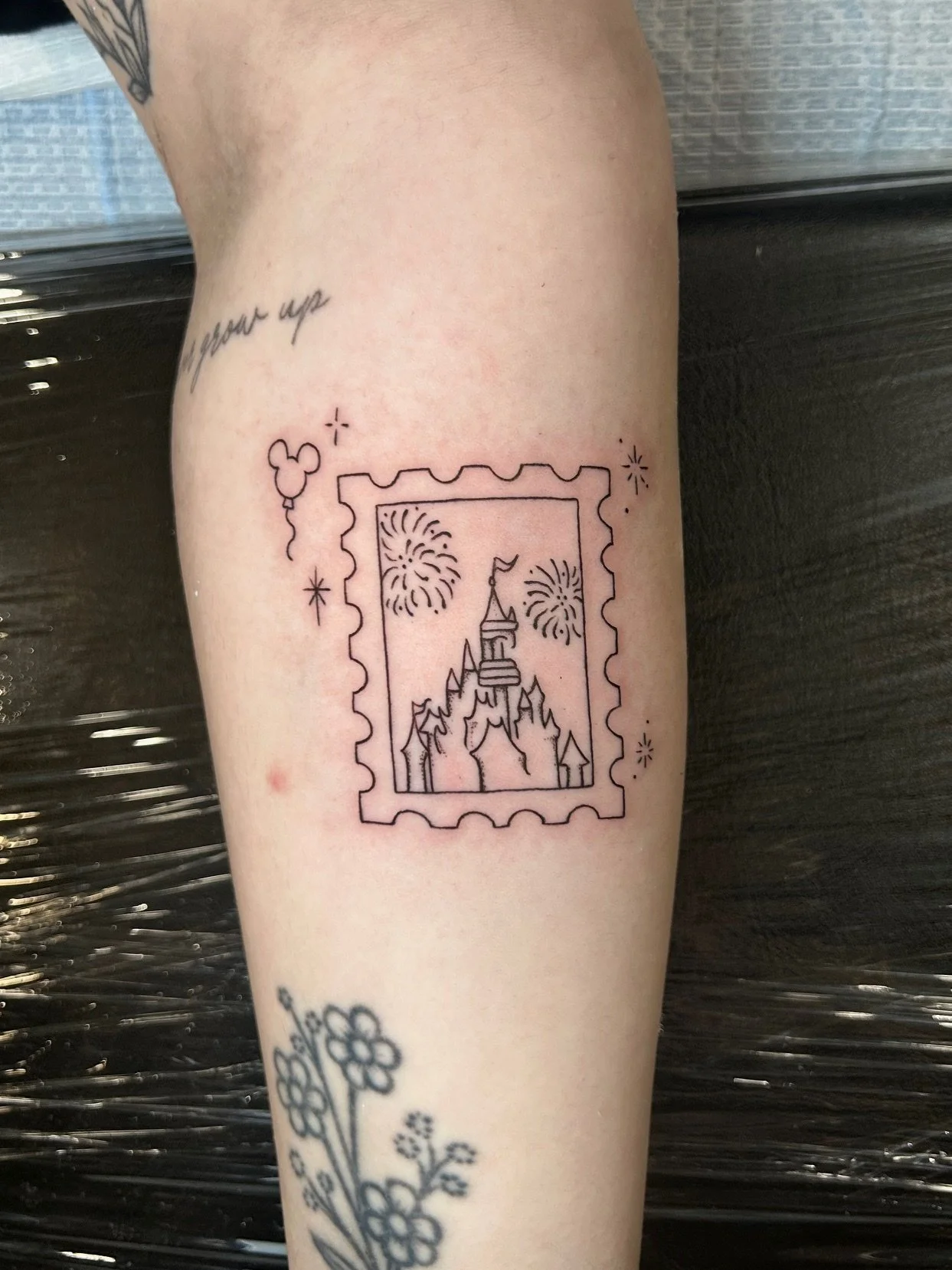 Fine line Disney stamp tattoo by Nicole Cosner at NW Finest Tattoo Co