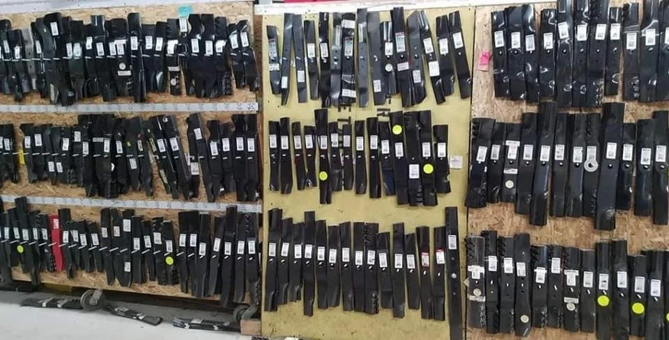 A wall of black gun magazines displayed on wooden shelves in a store or workshop.
