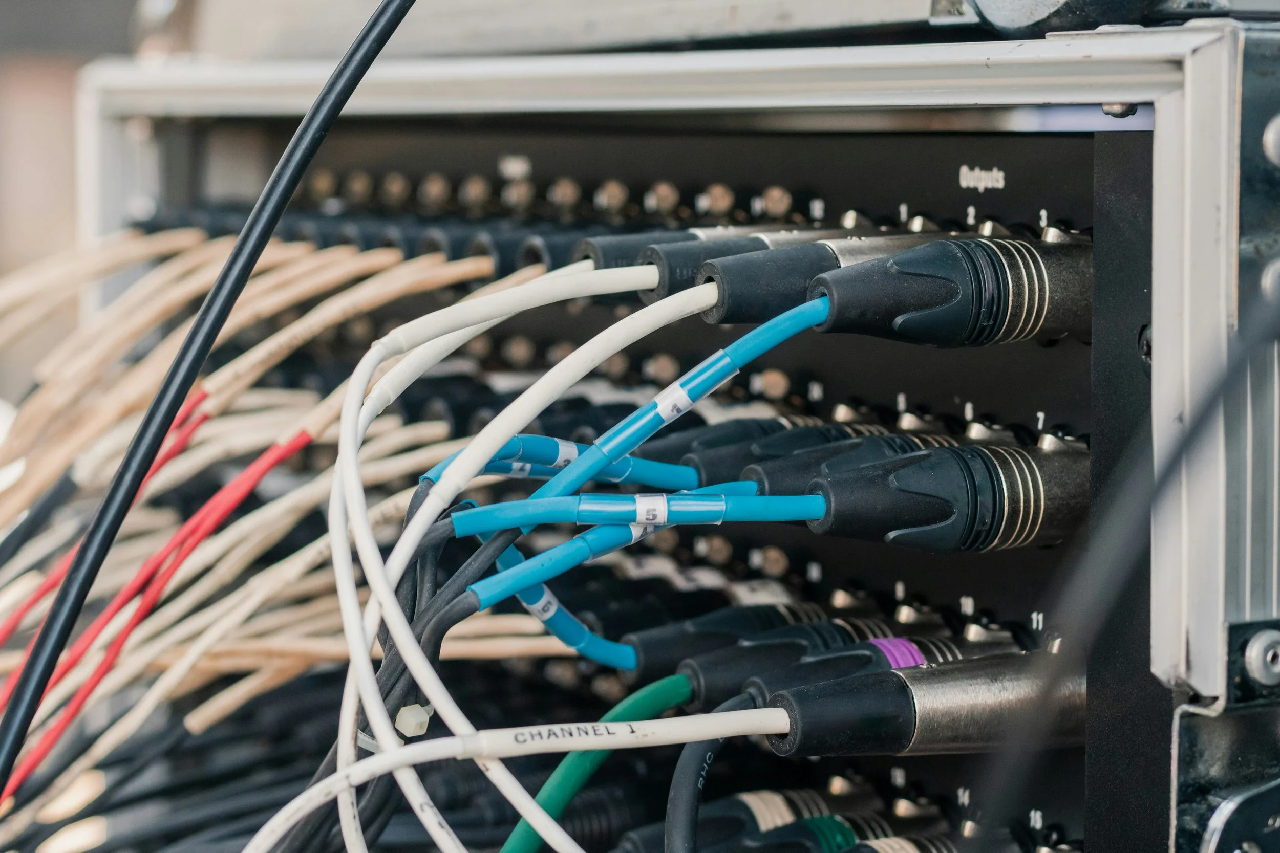 Close-up of a network patch panel with multiple colorful Ethernet cables plugged into it.