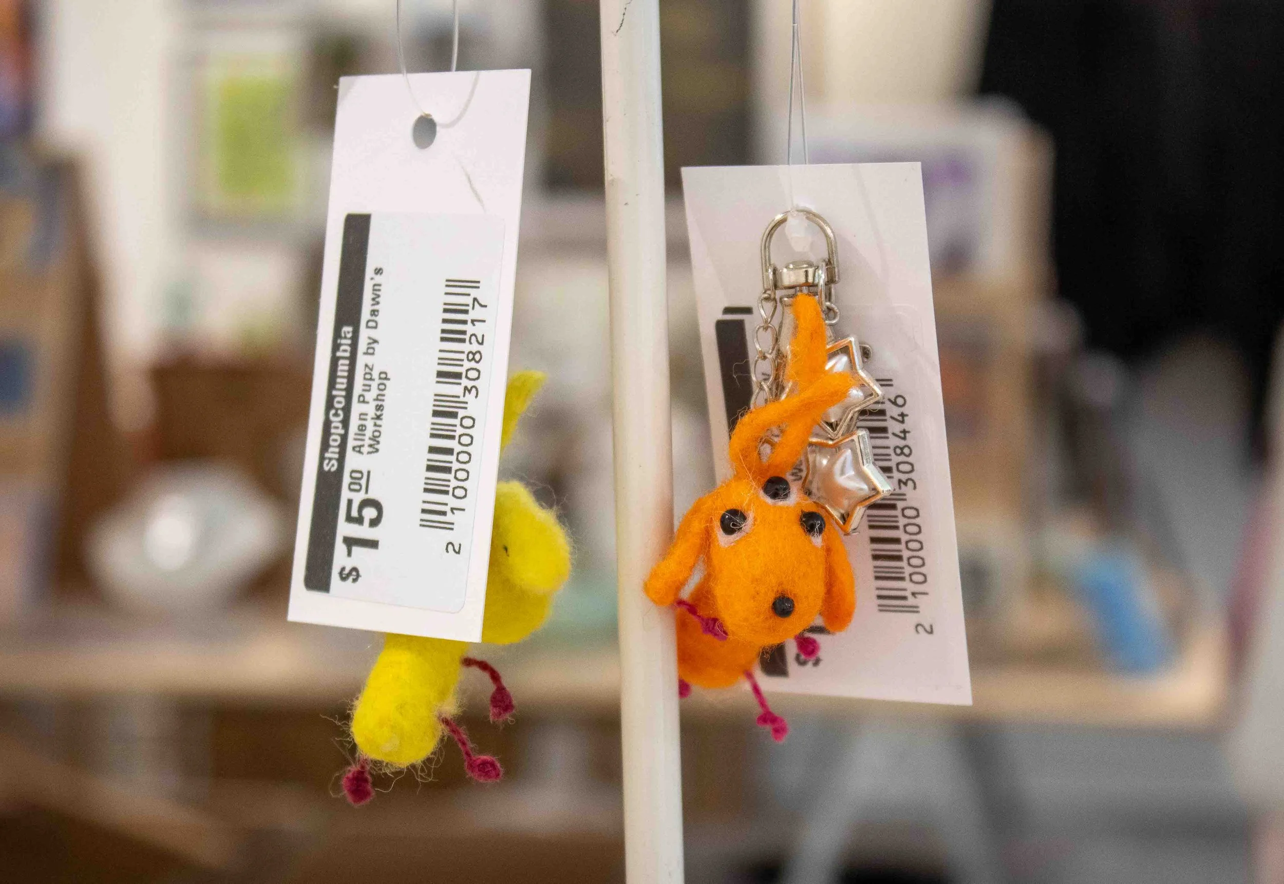  “Orange Alien Pupz” keychains by Dawn’s Workshop are shown hung up in the Shop Columbia display titled “MINI MINI: A Showcase of Miniature Works” during the artist reception on Thursday, Apr. 9, 2026. 
