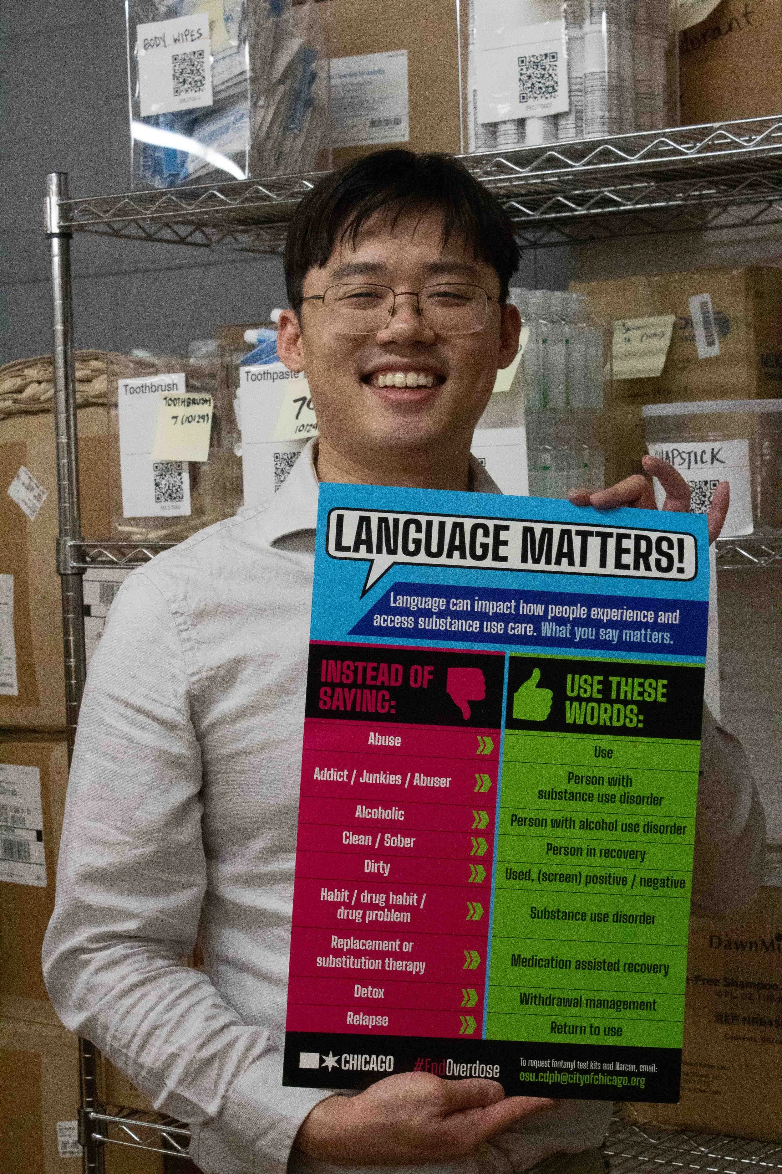 Ethan Yau holds a sign used to promote inclusive language in recovery care