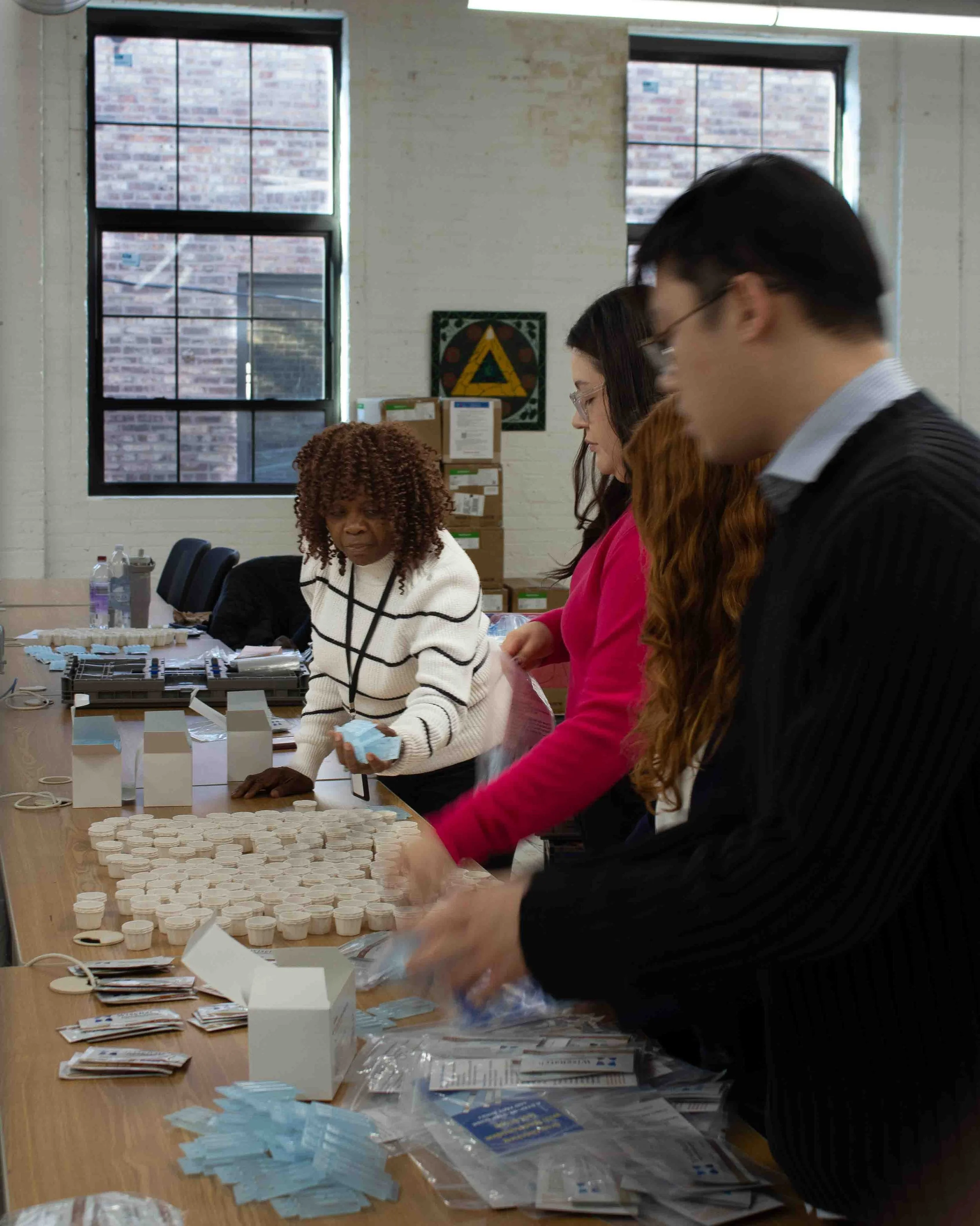 Shirley Tankersley packs testing kits alongside other office staff