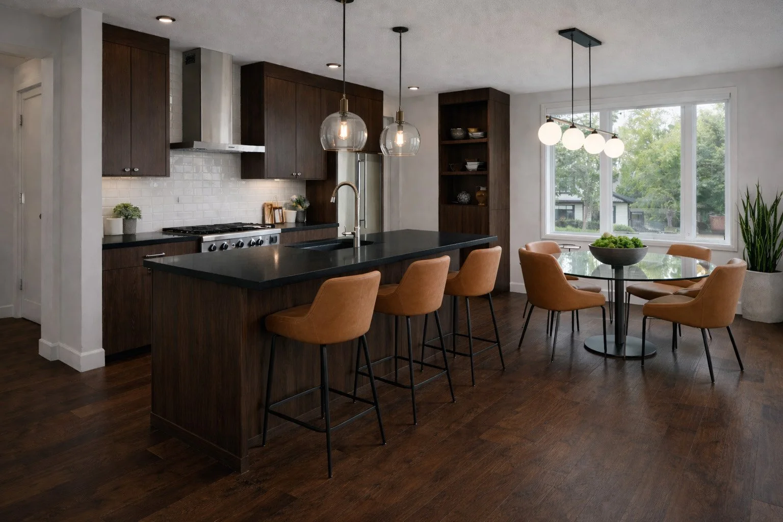 Modern kitchen with dark wood cabinets, black countertop island with tan chairs, large window, and dining area with tan chairs and a glass table.