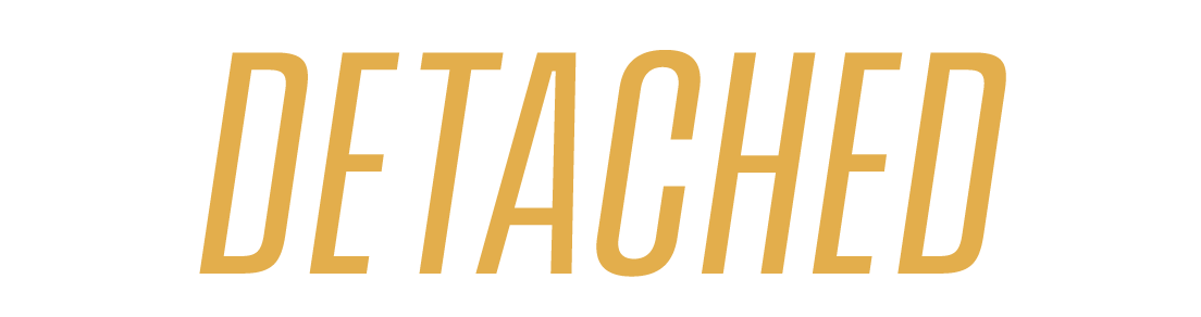 Text that says "DETACHED" in bold, uppercase letters with a gold color on a black background.