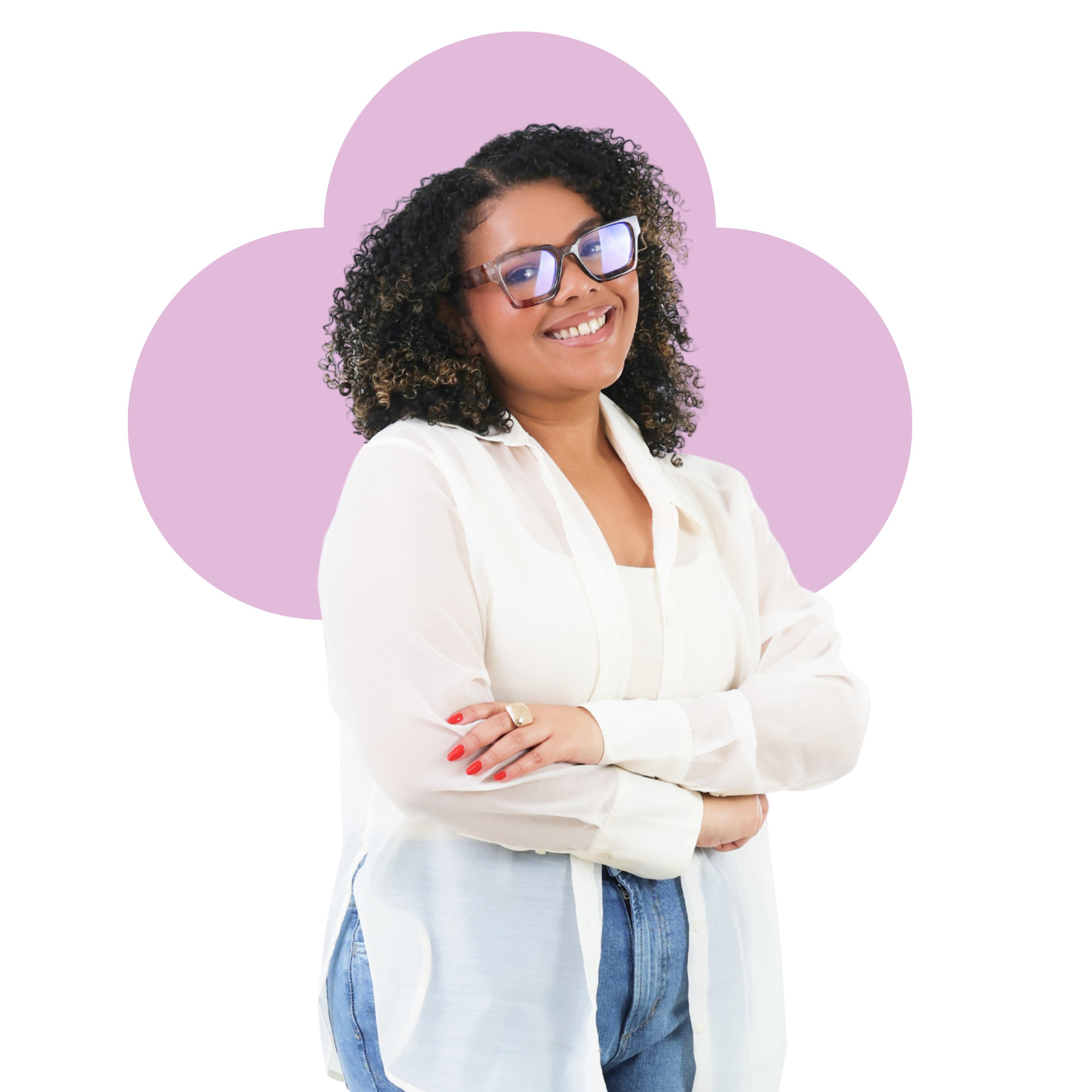 Smiling woman with curly hair and glasses, wearing a white shirt and jeans, standing with crossed arms against a purple background.