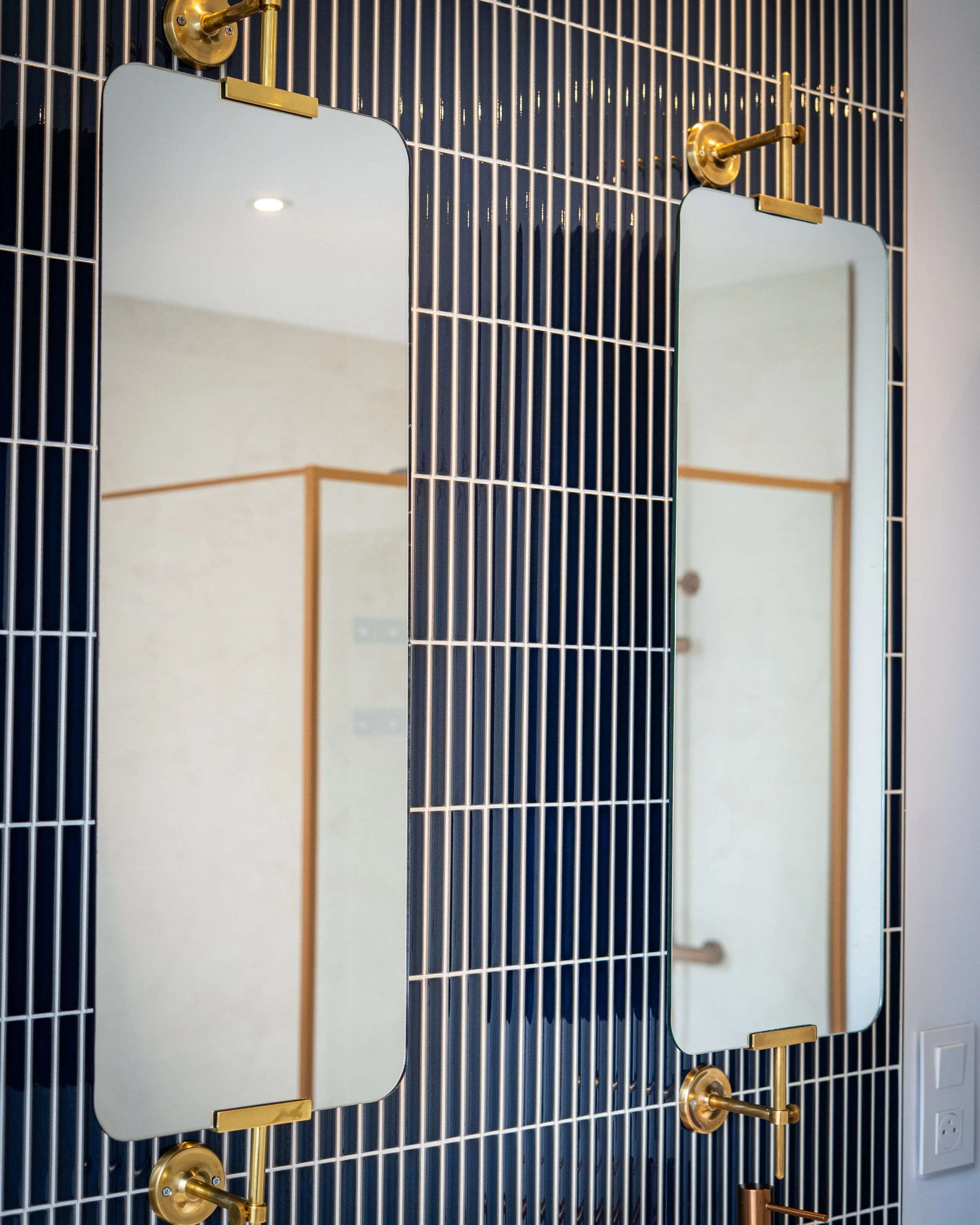 Miroir et robinetterie dorée sur carrelage bleu vertical salle de bain Tourcoing
