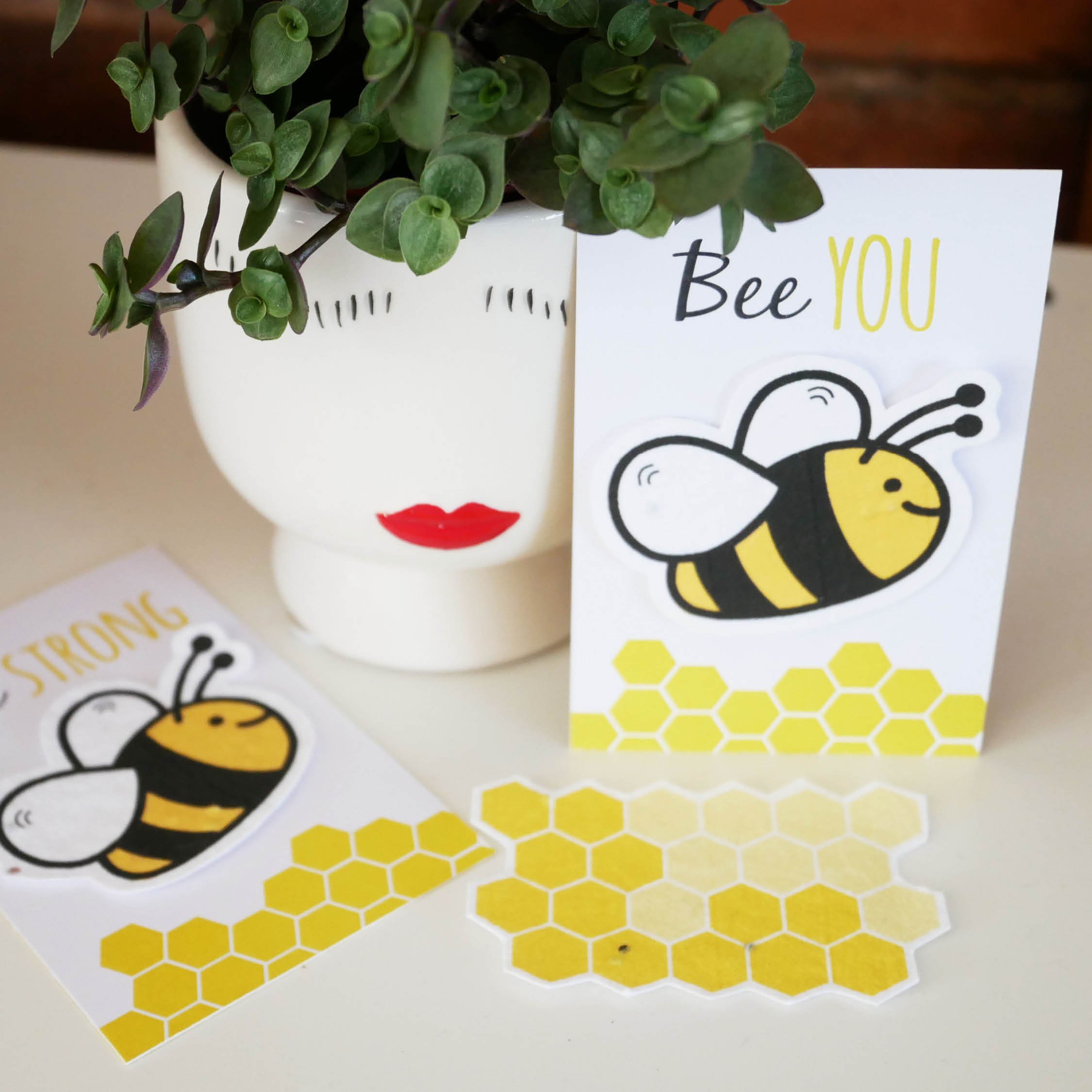 Bee cards on display next to plant