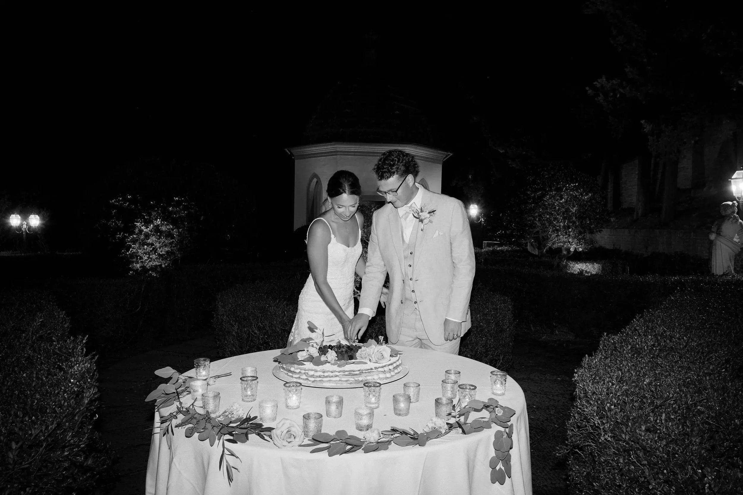 Bride and groom cutting cake at night in Italy