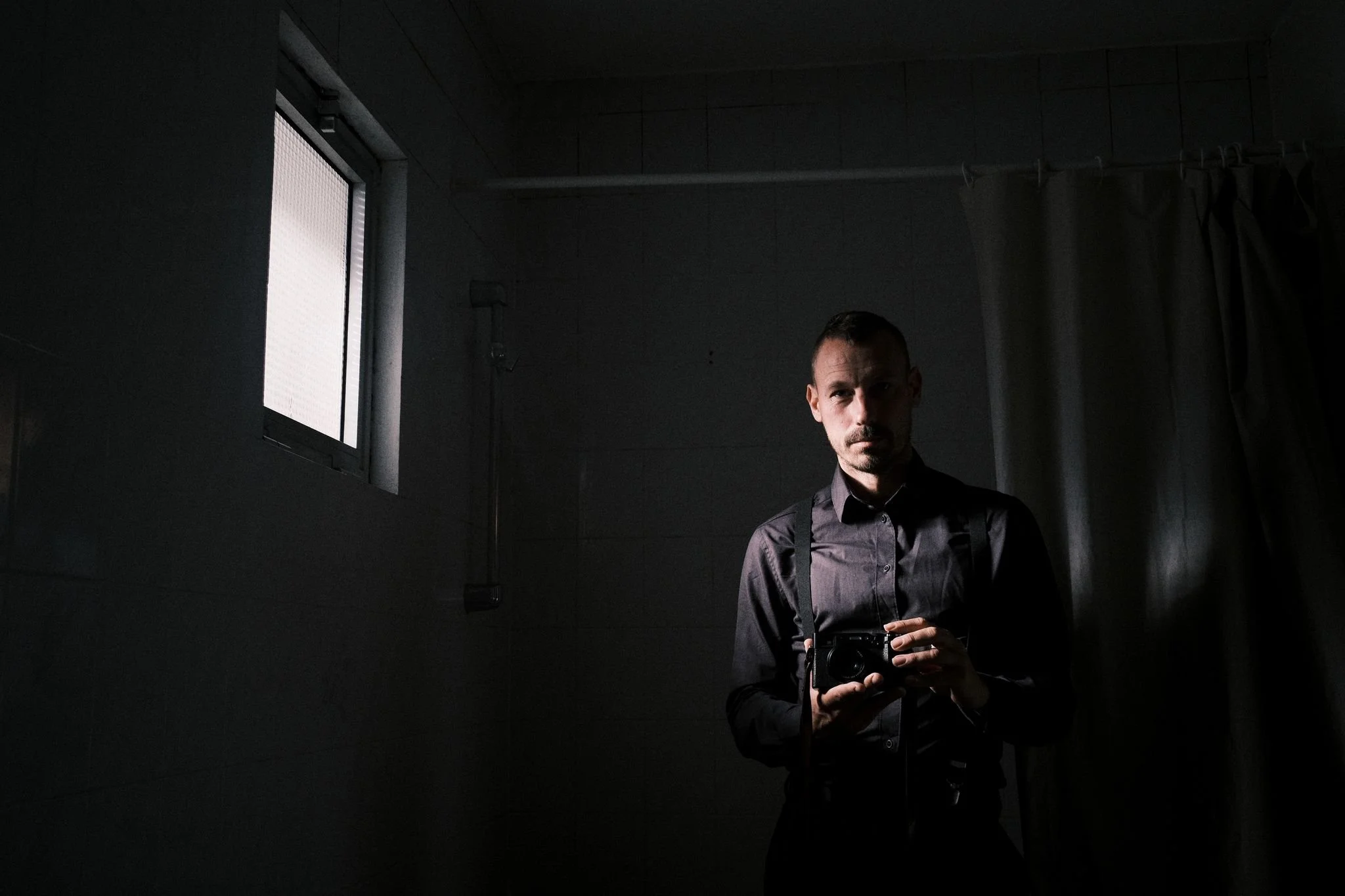 Bröllopsfotograf Anton Engblom i ett stilla ögonblick, speglad i en badrumsspegel – en bild om närvaro, eftertanke och dokumentärt fotografiskt seende.