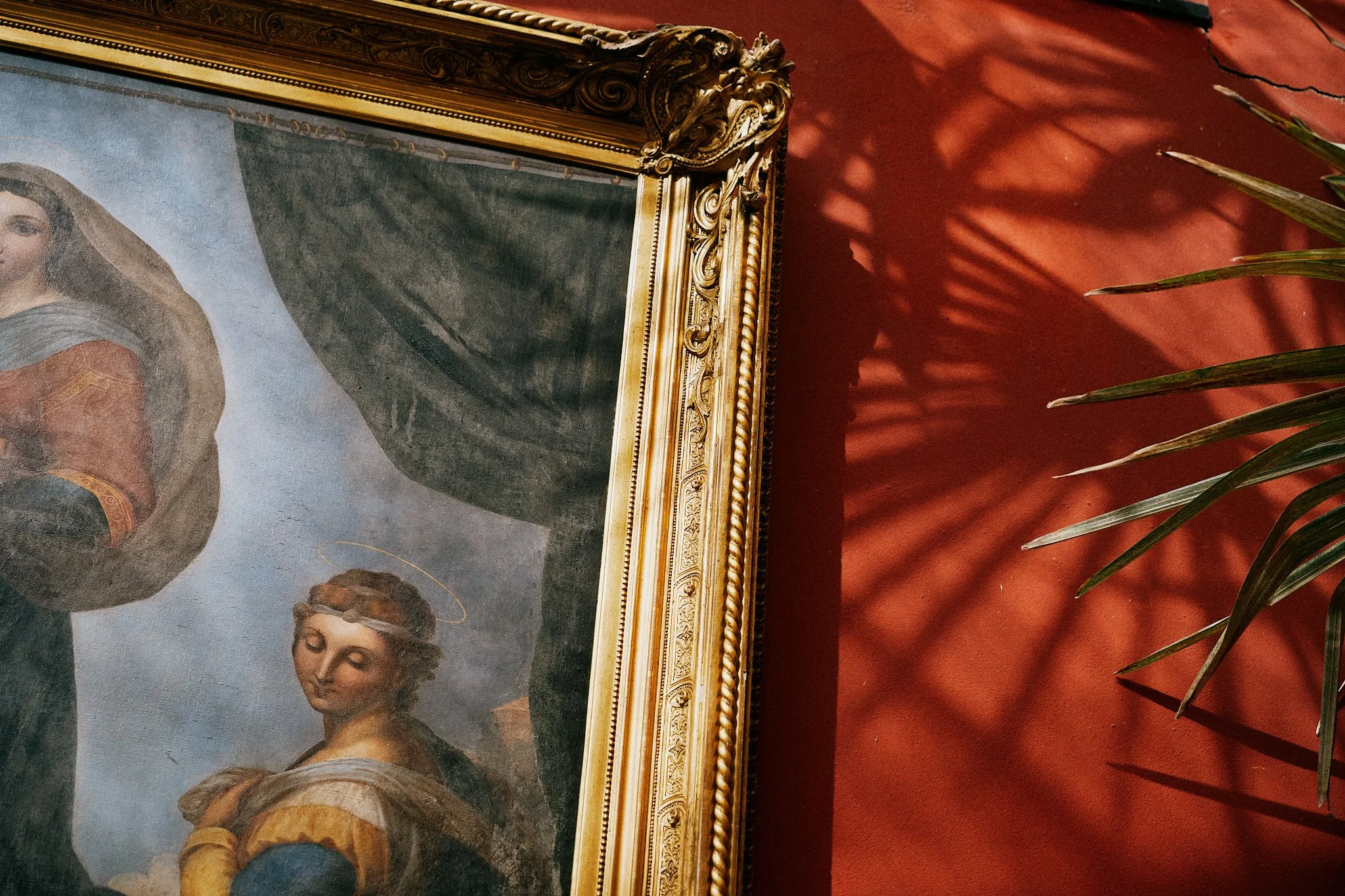 Del av ett gammalt konstverk i ett guldförbundet ramt, inklusive en man och en kvinna med gloria, samt en mörk skjorta och en ljus klänning, mot en mörk bakgrund.