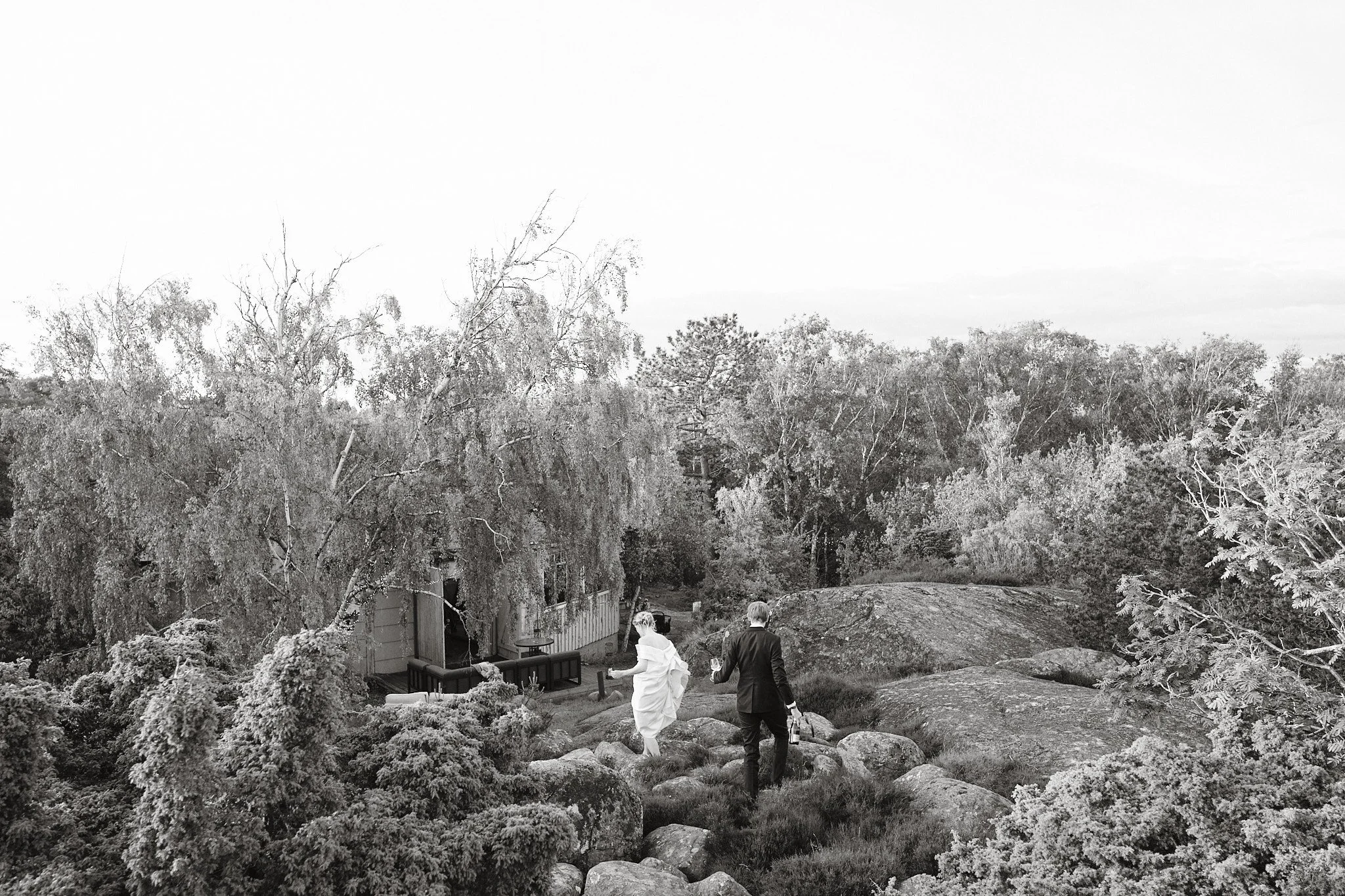 Brudpar rör sig genom klippor och natur i Göteborgs skärgård.