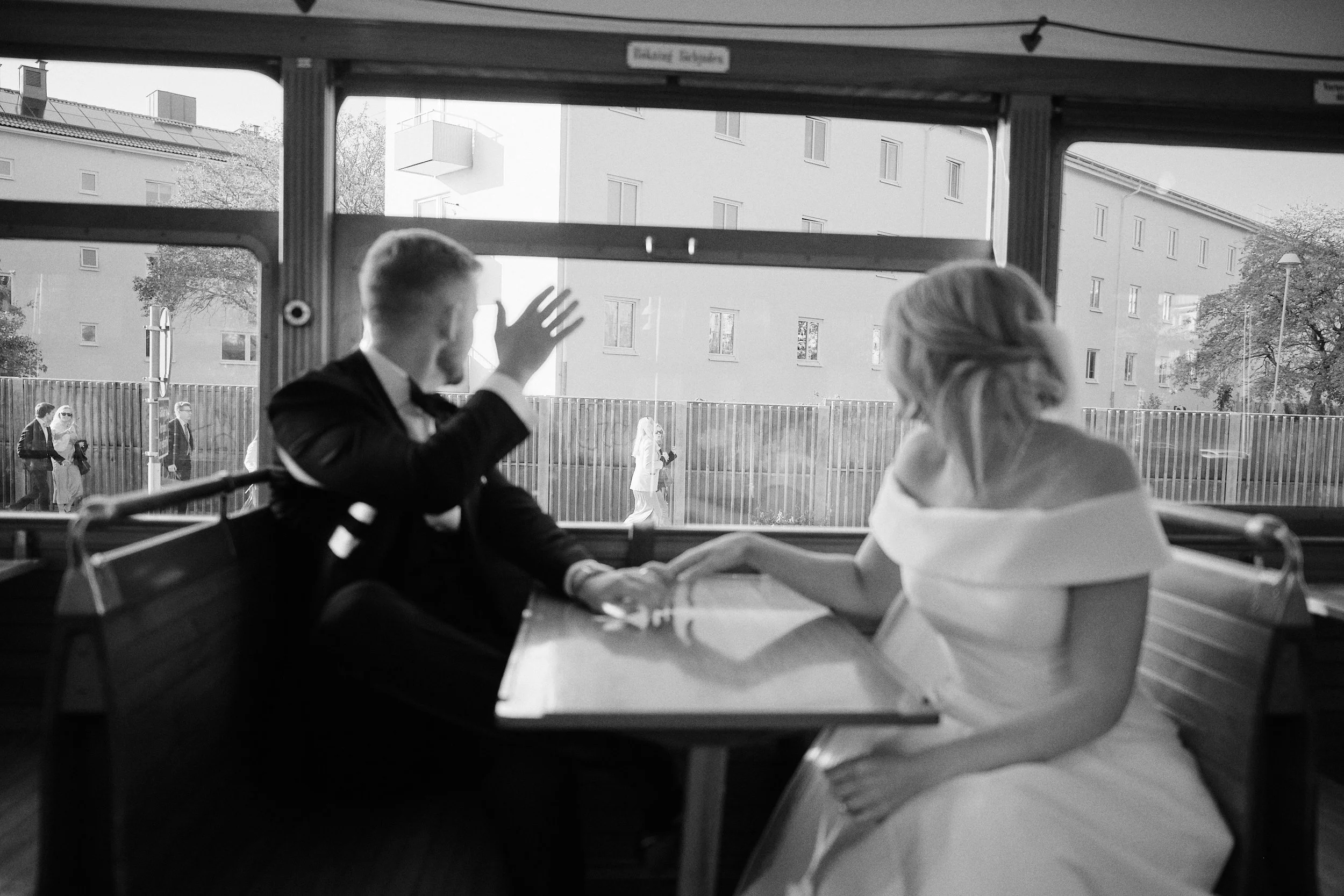 Bride and groom by window on tram in Gothenburg