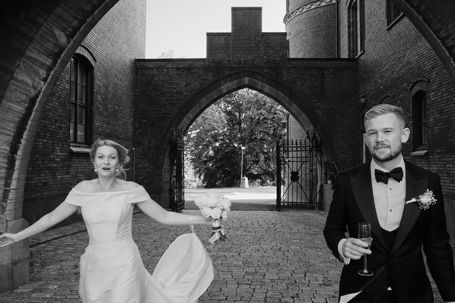 Brud och brudgum går genom en stenport efter vigseln