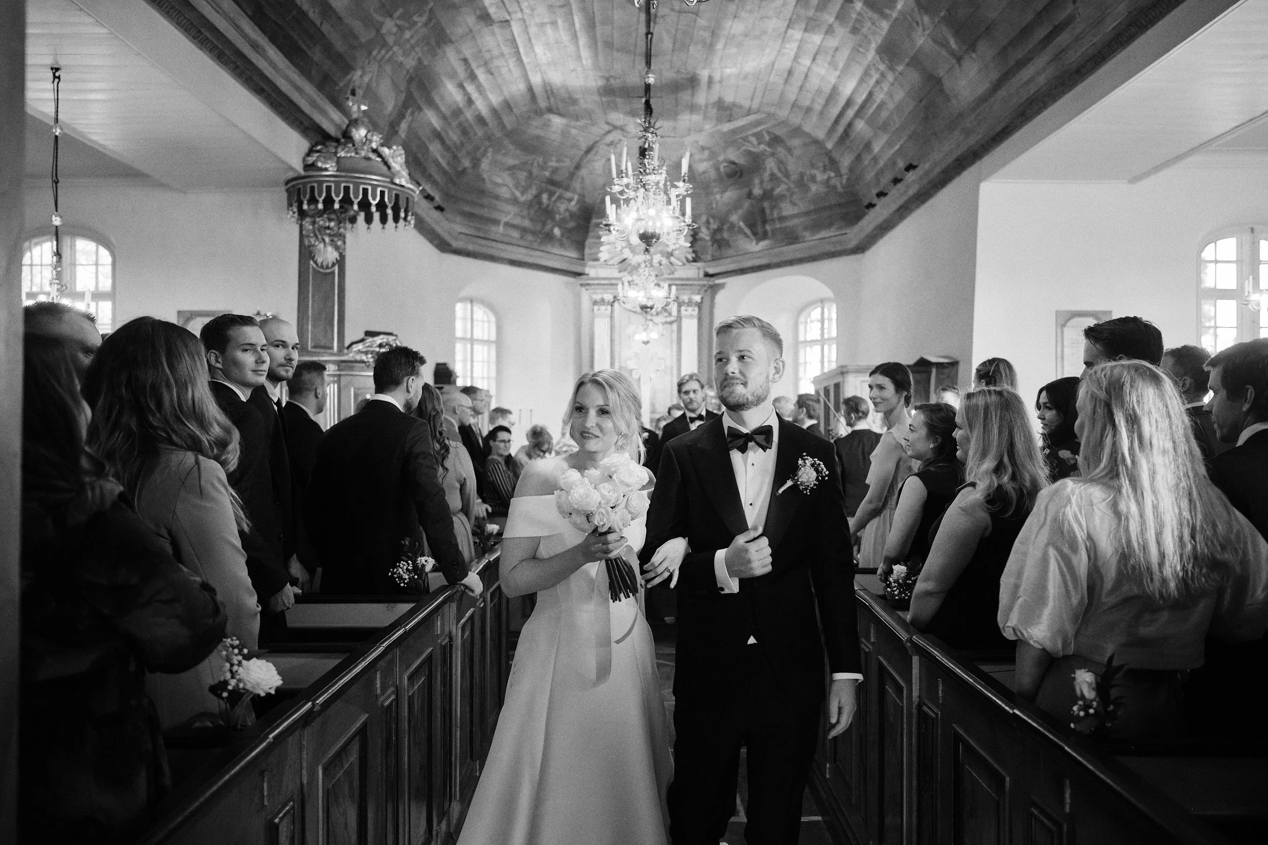 Bride and groom walking down the aisle at Örgryte Old Church in Gothenburg