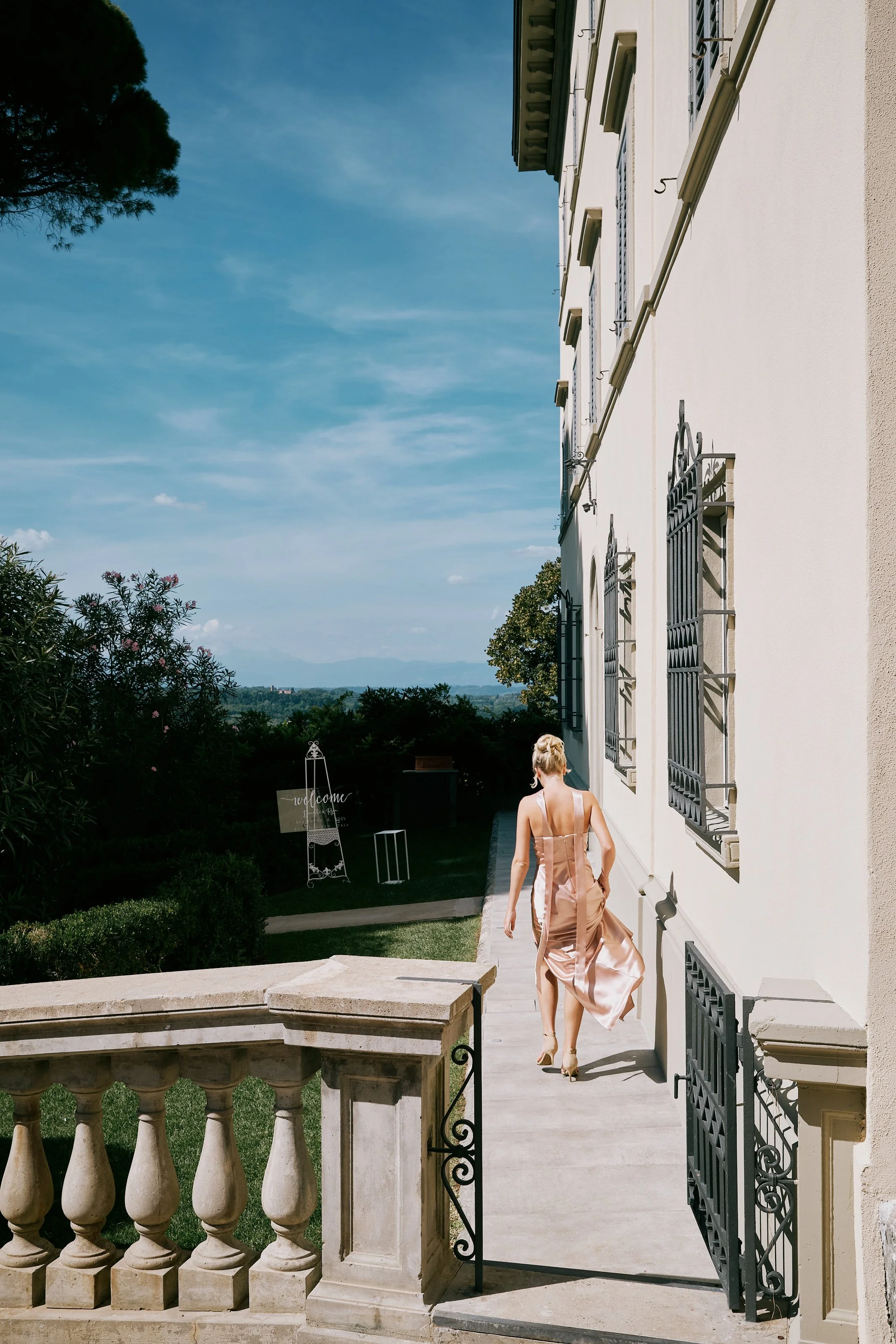 Guest walking outside Tuscan villa overlooking countryside