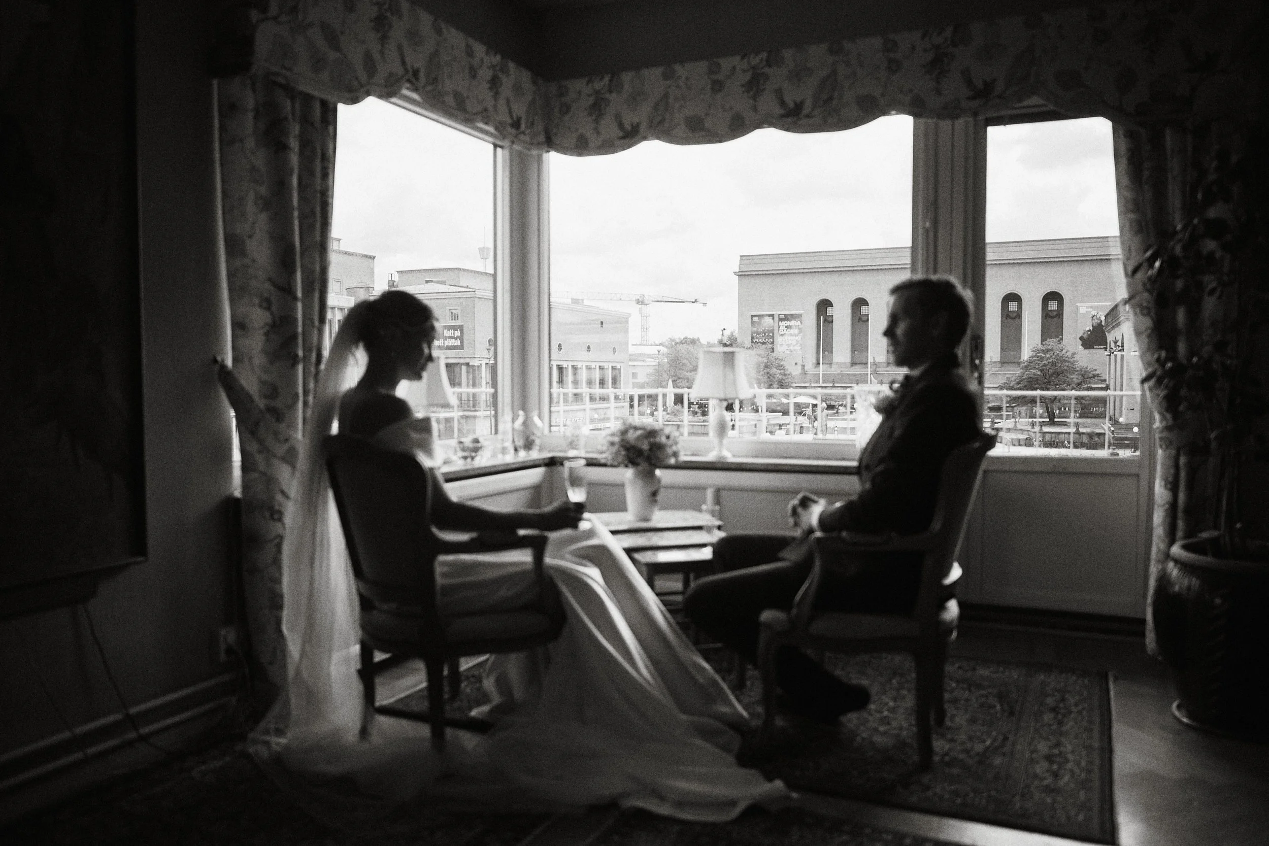 Brudpar under förberedelser i lägenhet i Göteborg med utsikt över Götaplatsen och konstmuseet – naturligt ljus och dokumentär stil.