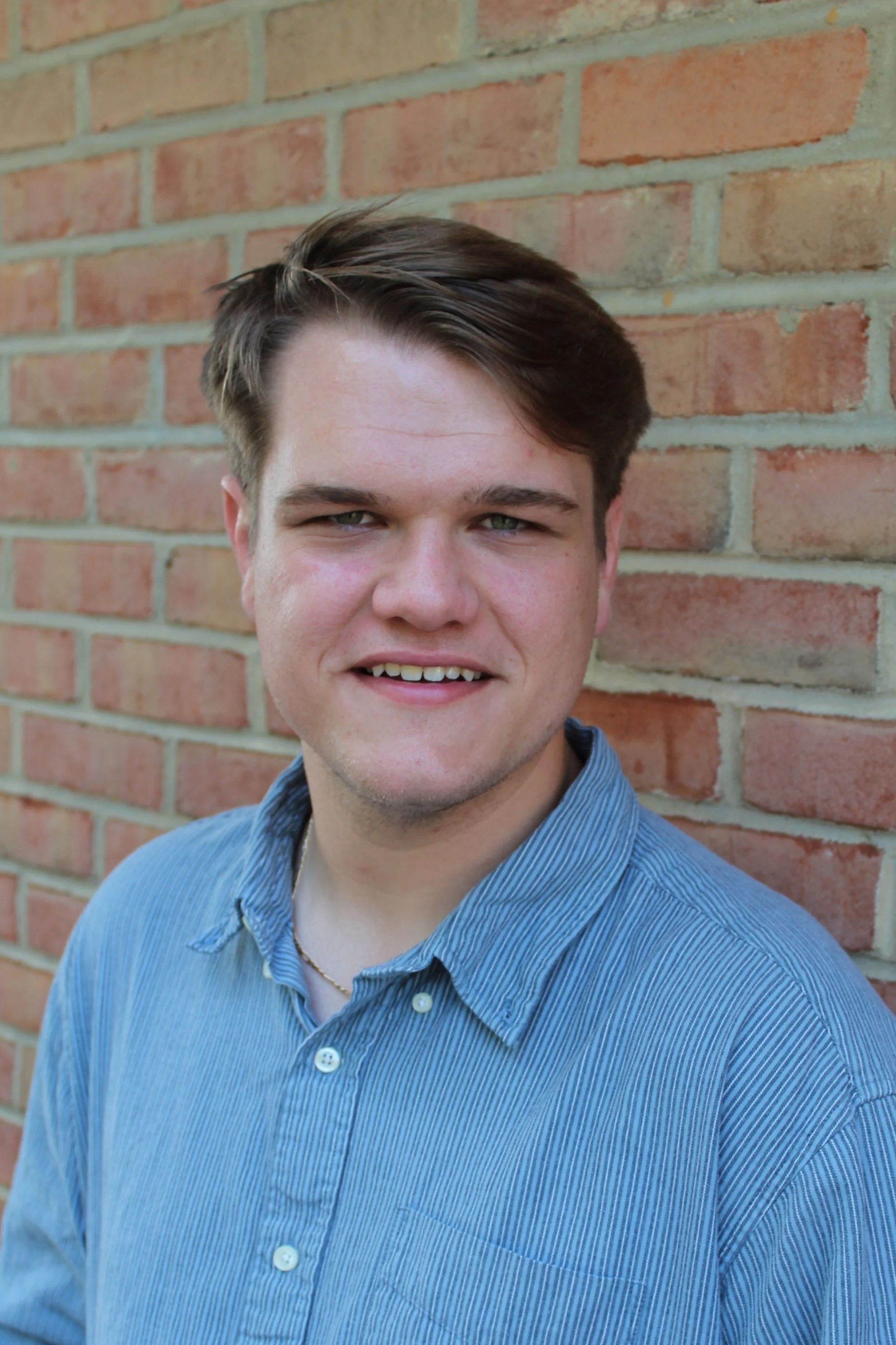 Headshot of Pastor Luke Norris, a young man with short brown hair, wearing a blue collared shirt.