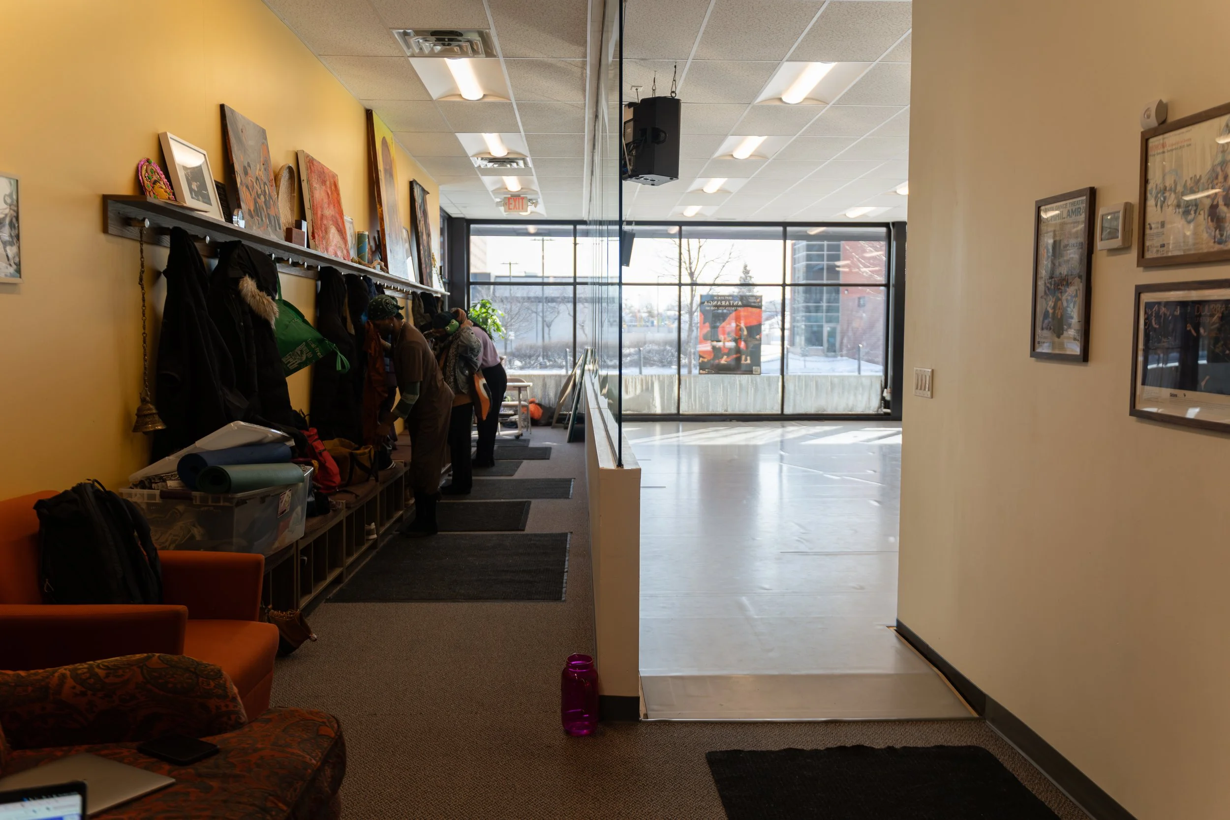 A view of the entry hall and a portion of the studio. The shelves of the entry hall are adorned with art created by our friends and collaborators.