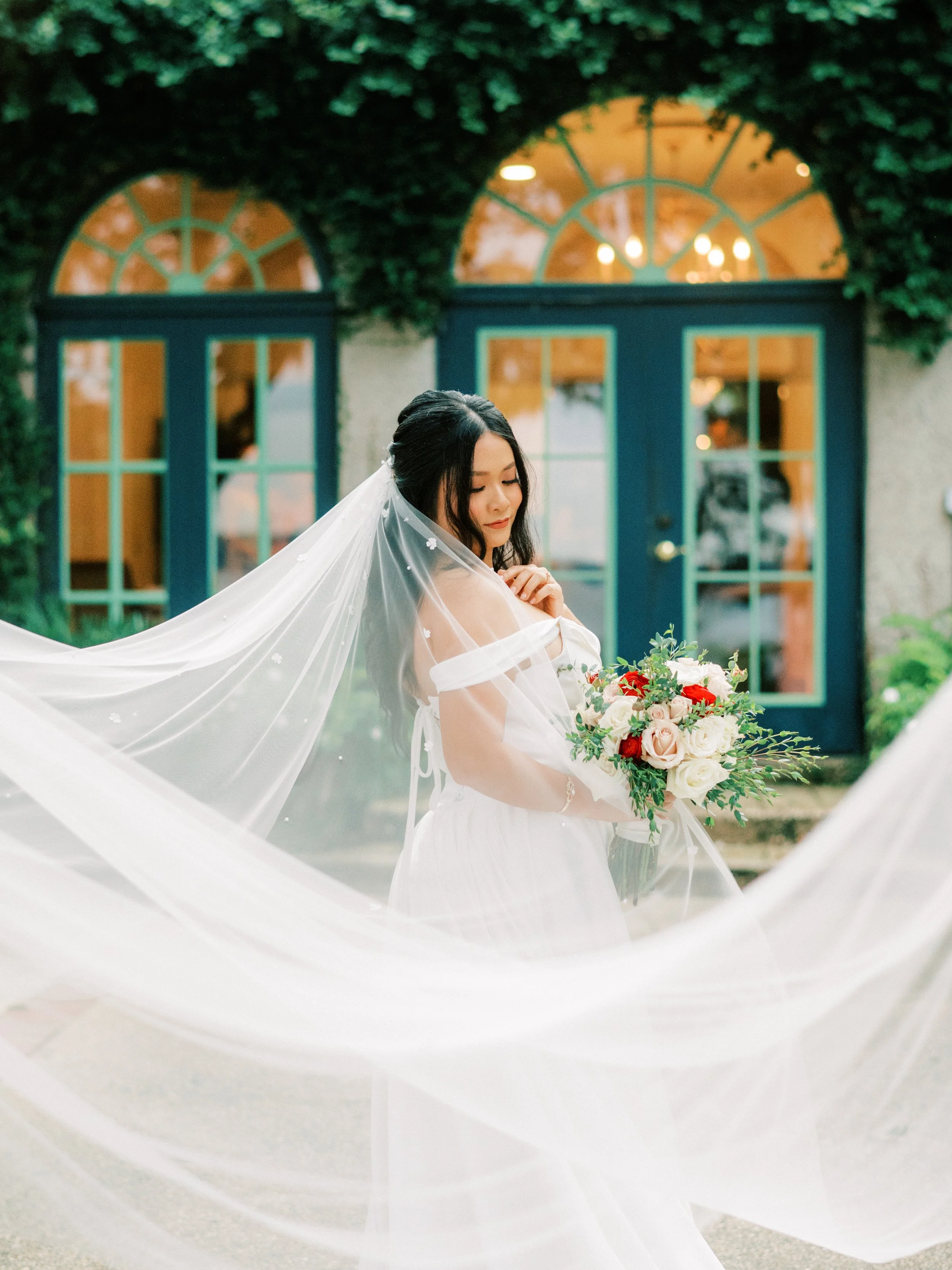A person in a white dress is holding a piece of fabric in their hands. Their hands are visible, and they are wearing a ring on one finger.
