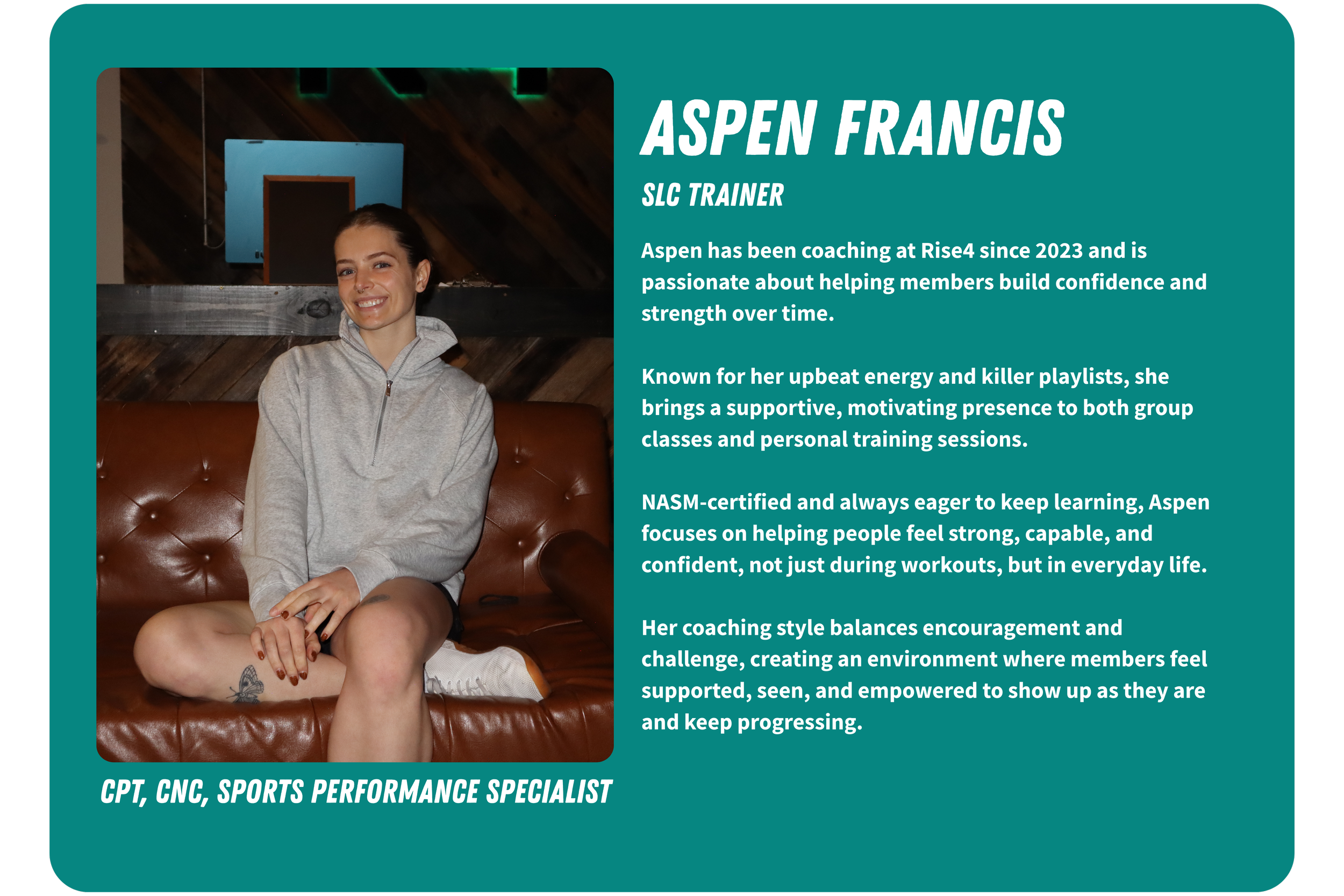 Photo of Aspen Francis sitting on a brown leather couch, wearing a gray hoodie, smiling, with a background of wooden walls and a blue rectangular decoration.