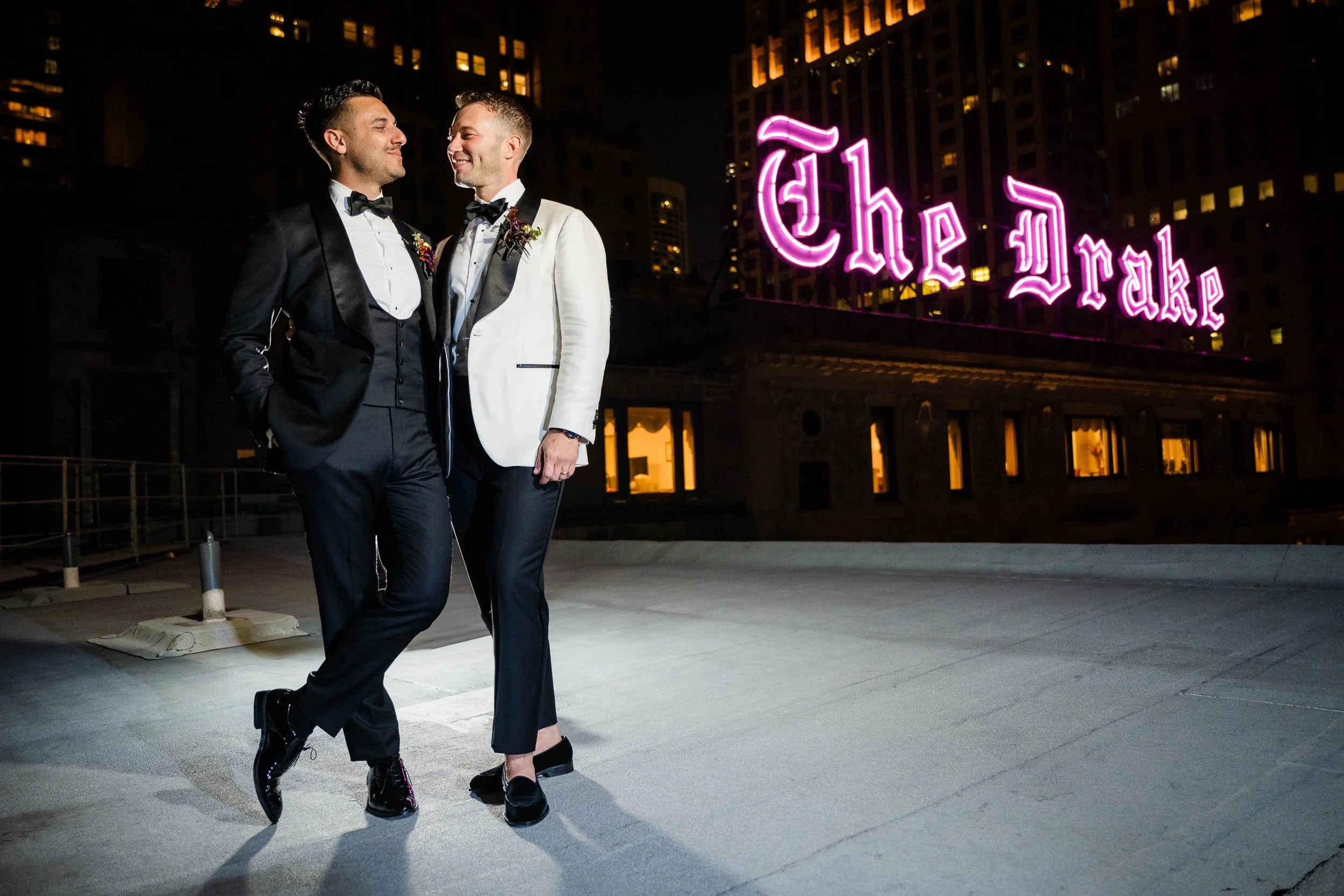 The Drake | creative dramatically light night portrait of grooms with iconic neon on The Drake's rooftop | Chicago IL