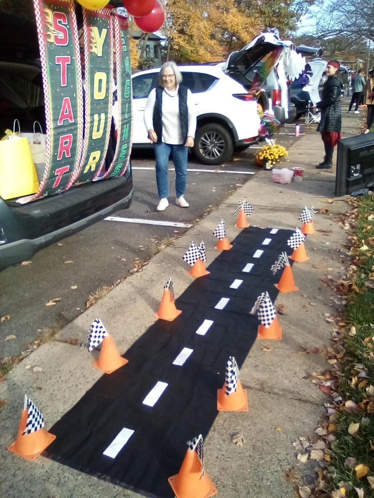 Decorated car trunks and a cone-lined racetrack set up for the St. Matthew's Weekday School Fall Festival