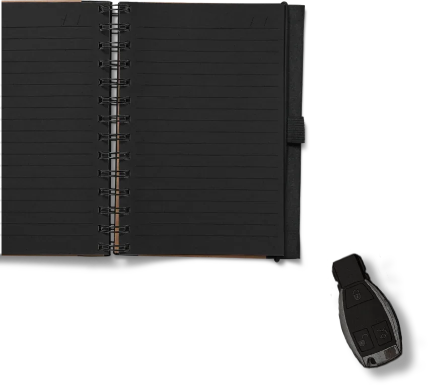 Un carnet noir ouvert avec une clé de voiture à côté.