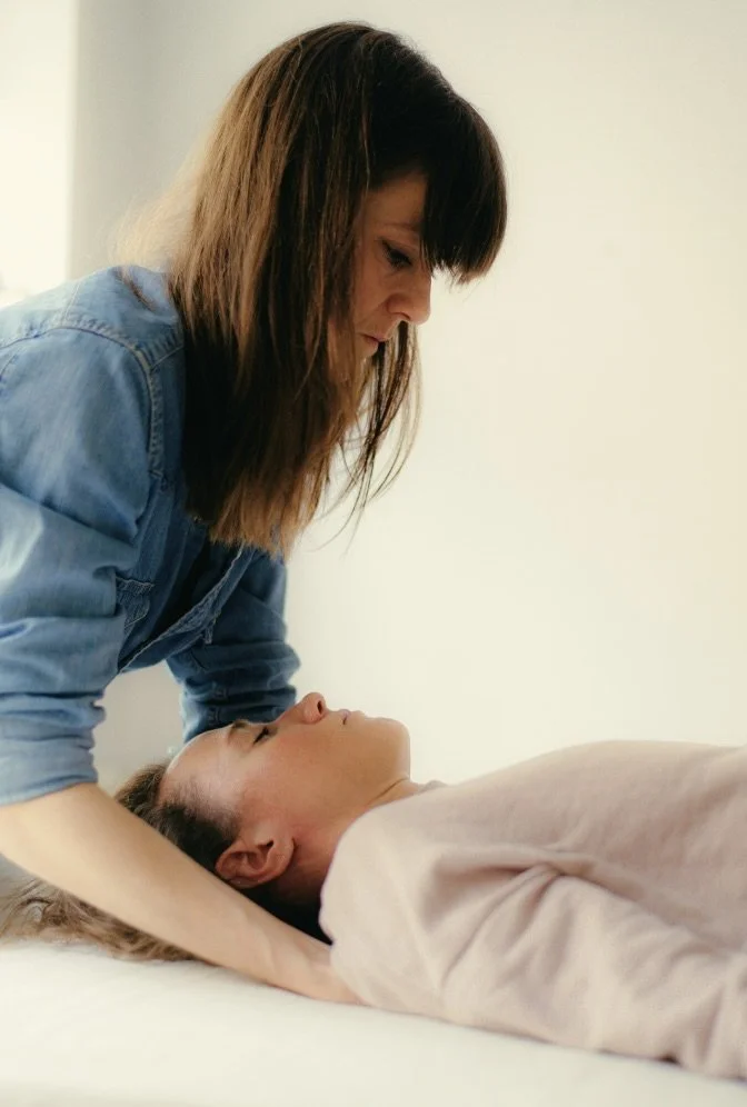 A woman providing chest compressions in a CPR training scenario on a woman lying on a mat.
