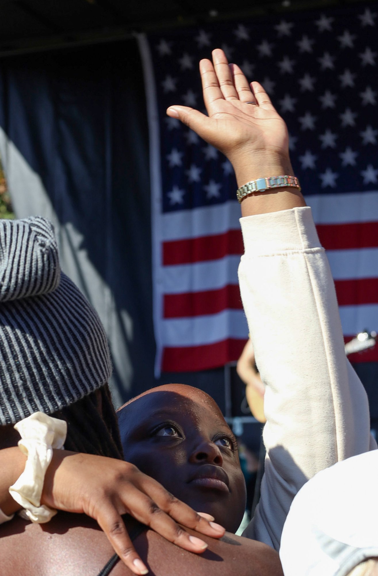 BOSTON, MA--10.18.25--One protester embraces another while looking up and holding their arm up in front of the stage, during the No Kings Protest at the Boston Common last Saturday. This came after a brief altercation between counter protesters in th
