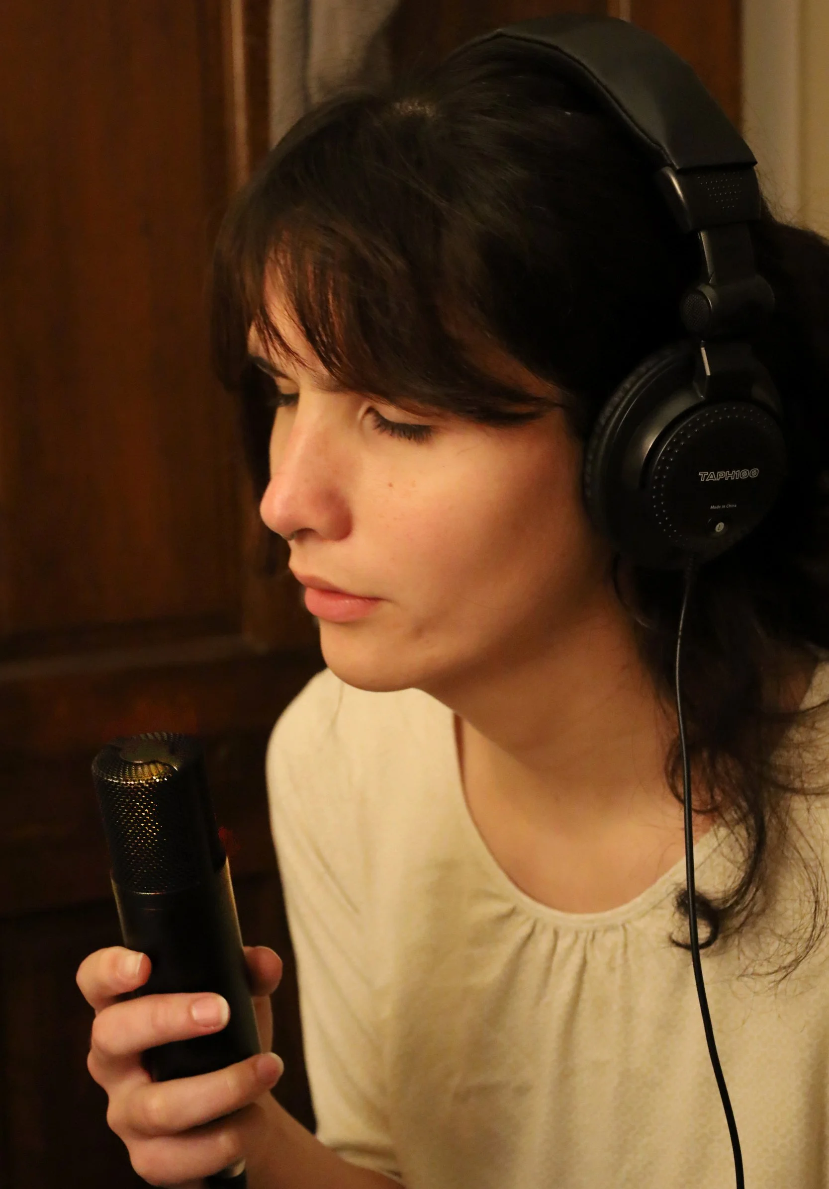 BOSTON, MA--10.15.25--Maggie Ma sings into her microphone with headphones on, recording vocals to an original song in her room.