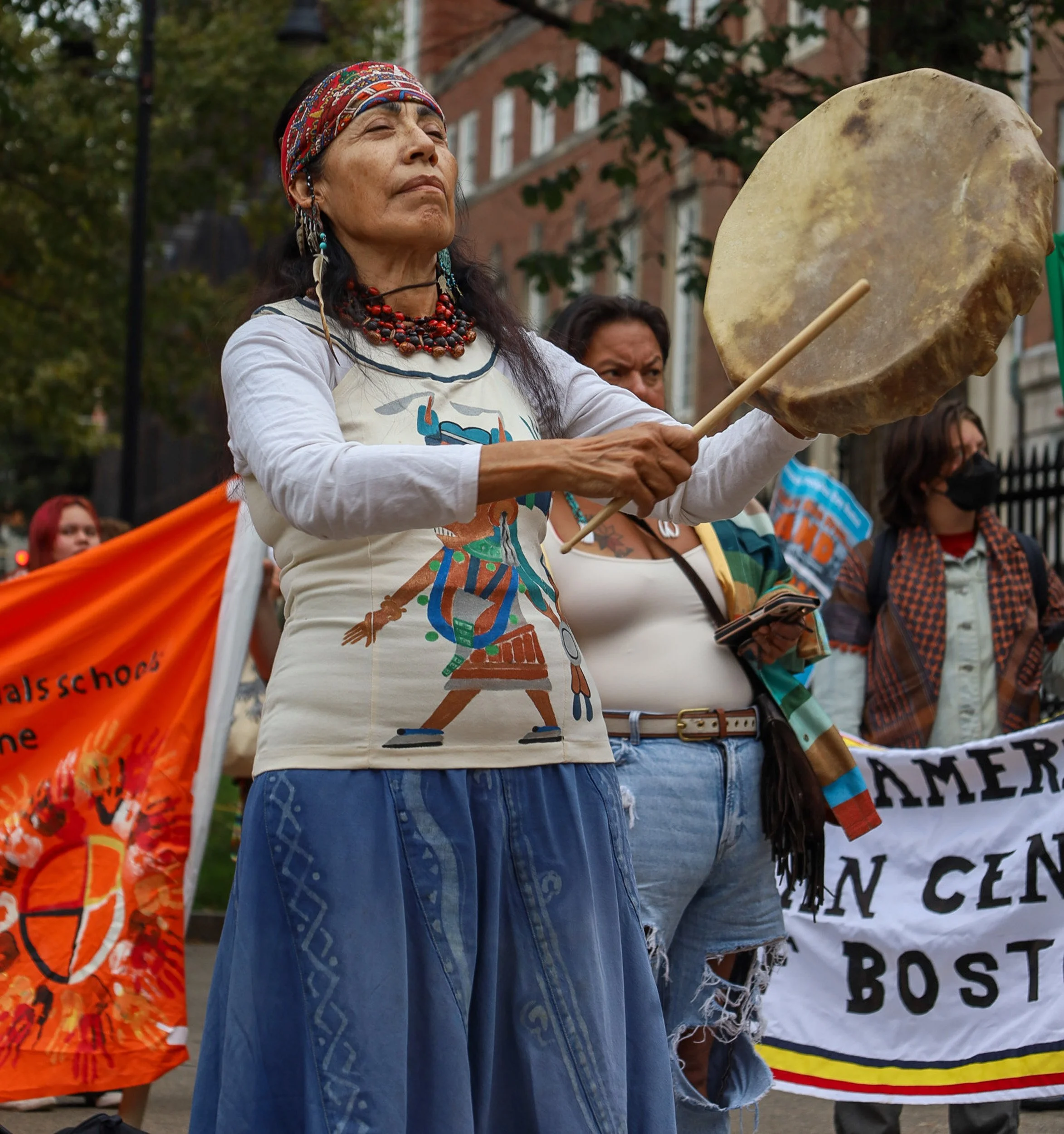 BOSTON, MA--10.11.25--Rosalba Solis beats a drum to commemorate the Indigenous land at the Boston Common. The ceremony came prior to the Indigenous Peoples' Day March down Tremont Street with Indigenous communities and allies. 