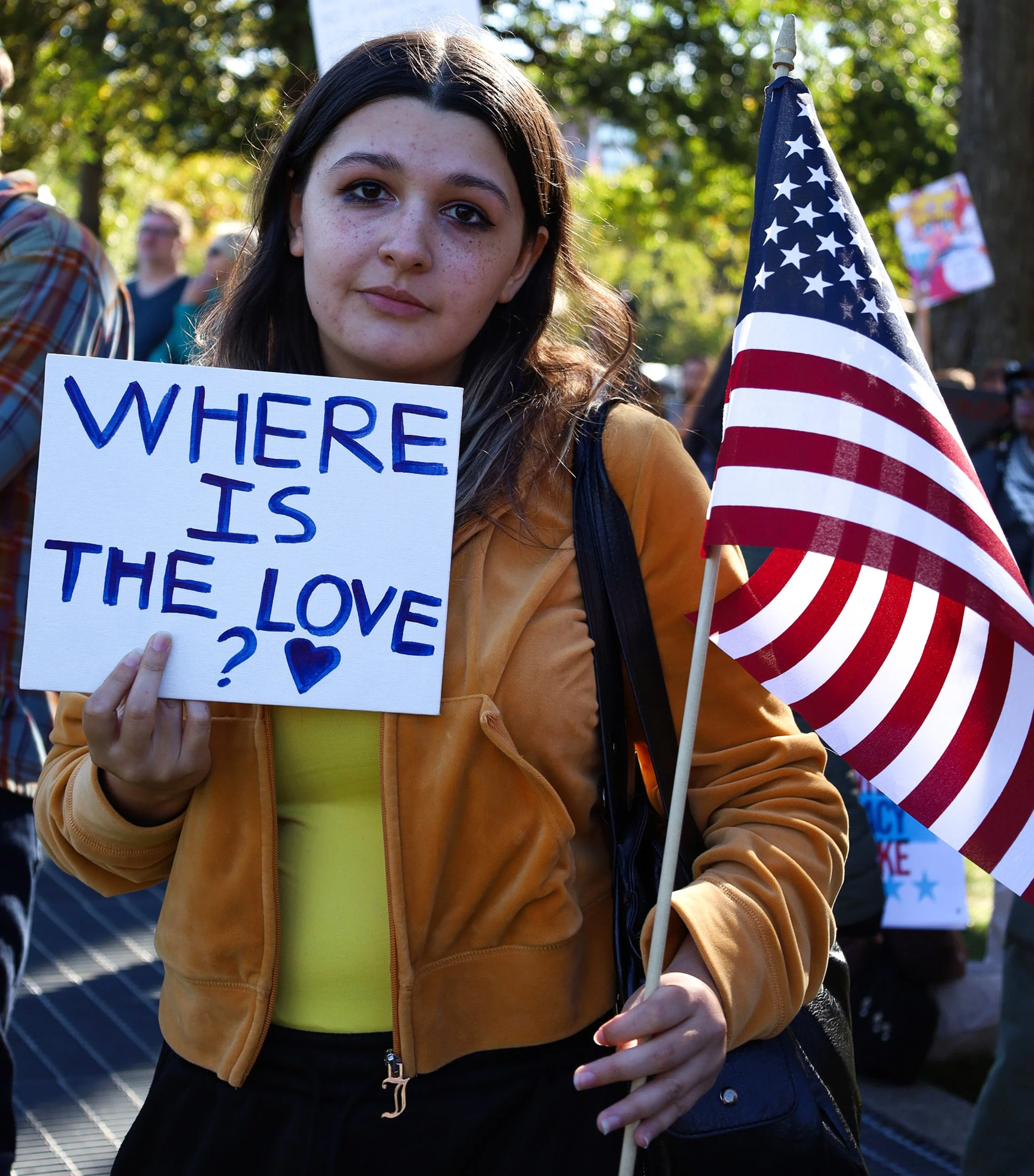 BOSTON, MA--10.18.25--Isabel Rosario holds an American flag and a sign that says "Where Is The Love?" during the No Kings Protest at the Boston Common. 