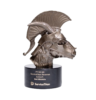 A metallic award trophy shaped like a goat's head with large curved horns, mounted on a black base with text.