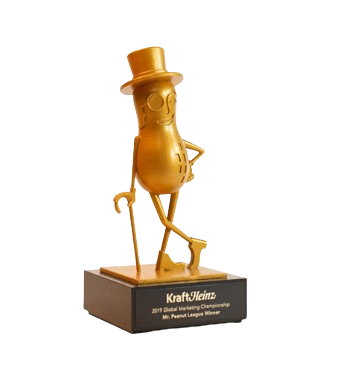A trophy resembling a peanut character wearing a top hat and holding a flag, mounted on a base that reads 'Kraft Heinz 2018 Global Glazing Championship Most Peanuts Winner'.