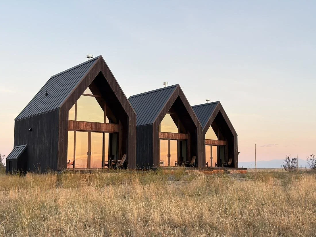 Three Reed Retreat cabins at sunset on open grassland
