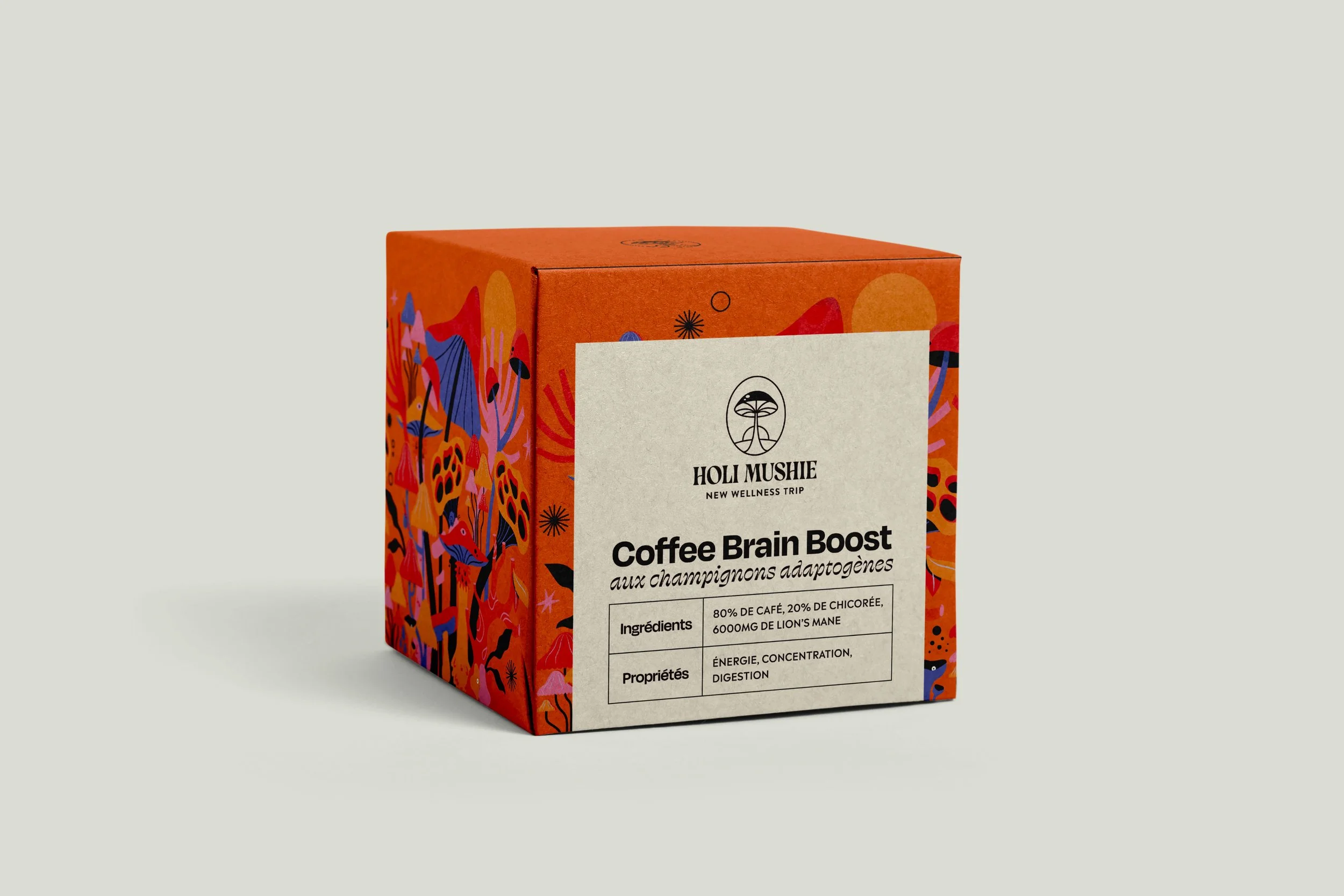 Boîte de thé de couleur orange avec un dessin coloré de champignons et de nature, étiquette blanche indiquant 'Coffee Brain Boost' aux champignons adaptogènes, avec des détails sur les ingrédients, propriétés et un logo de forêt stylisé.