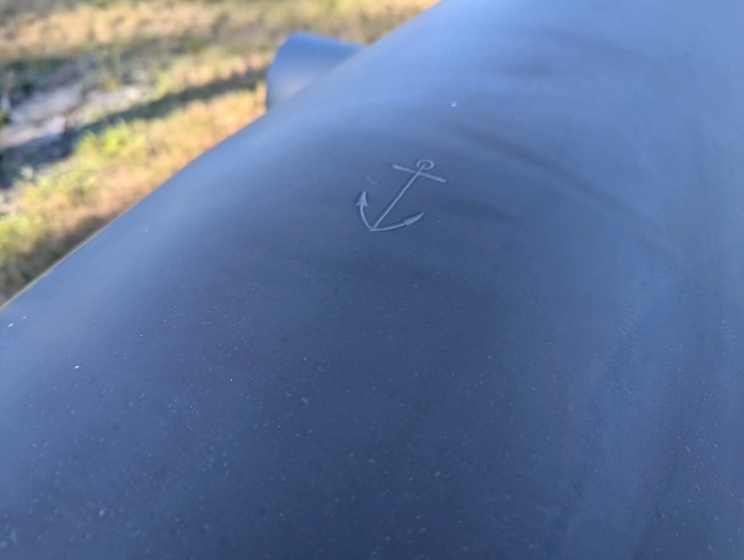 A US Navy anchor is stamped on top of the tube