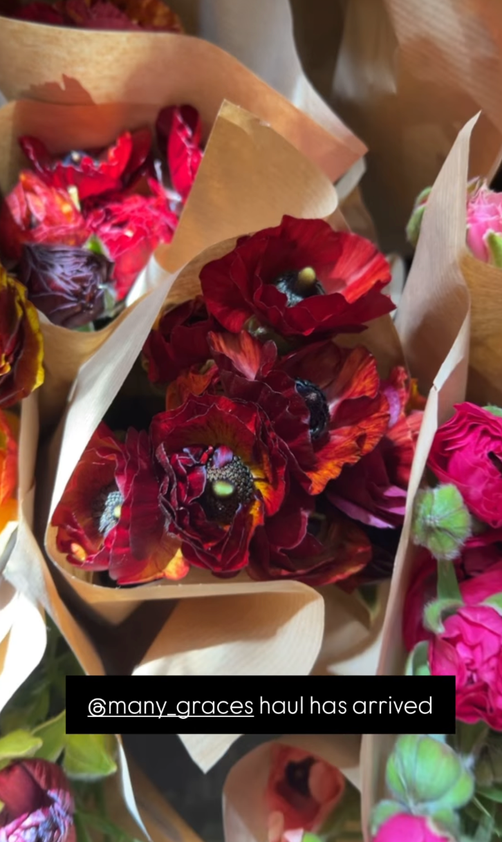 Bouquets of red and pink flowers wrapped in brown paper.