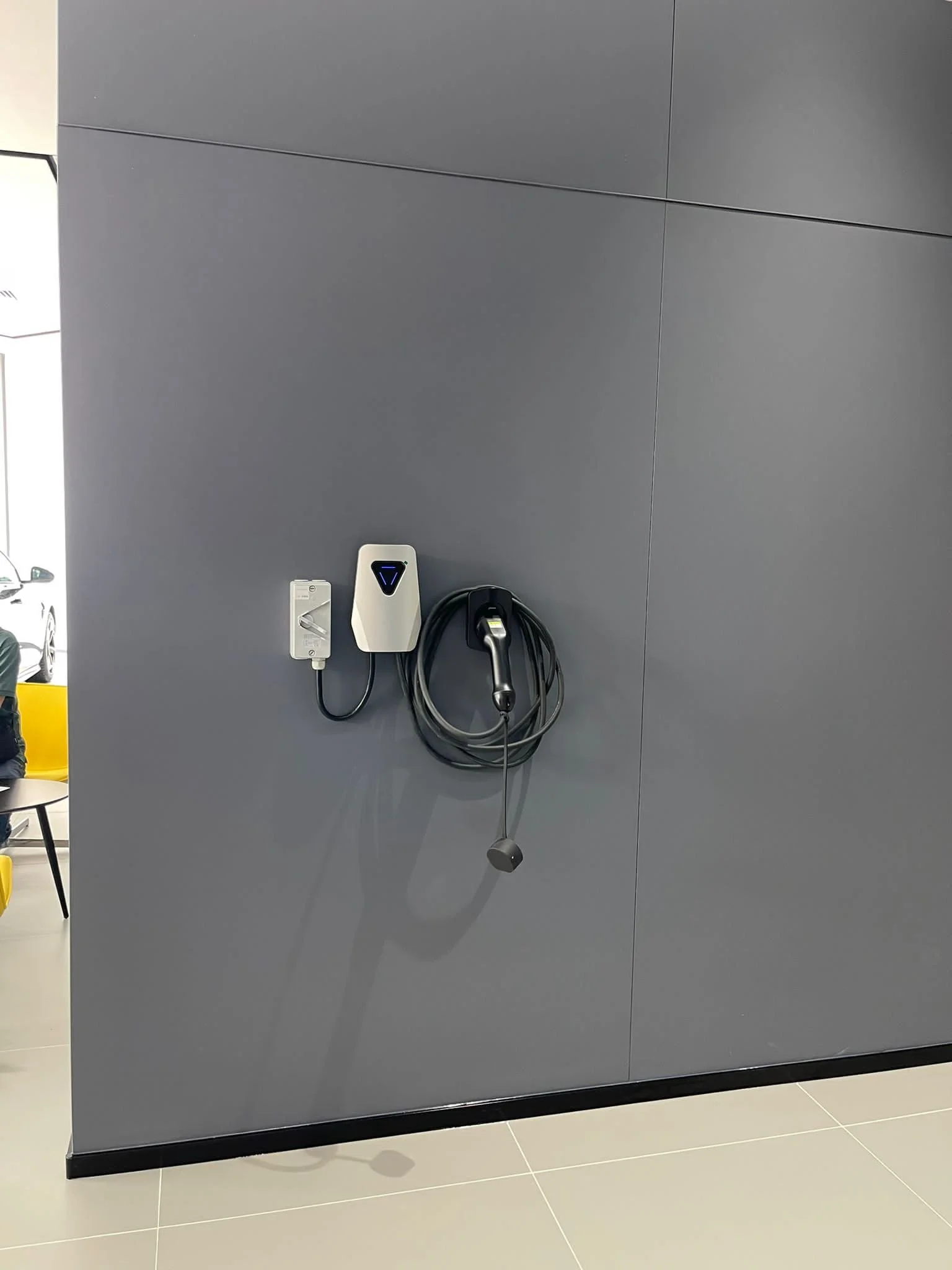 Electric vehicle charging station mounted on a gray wall