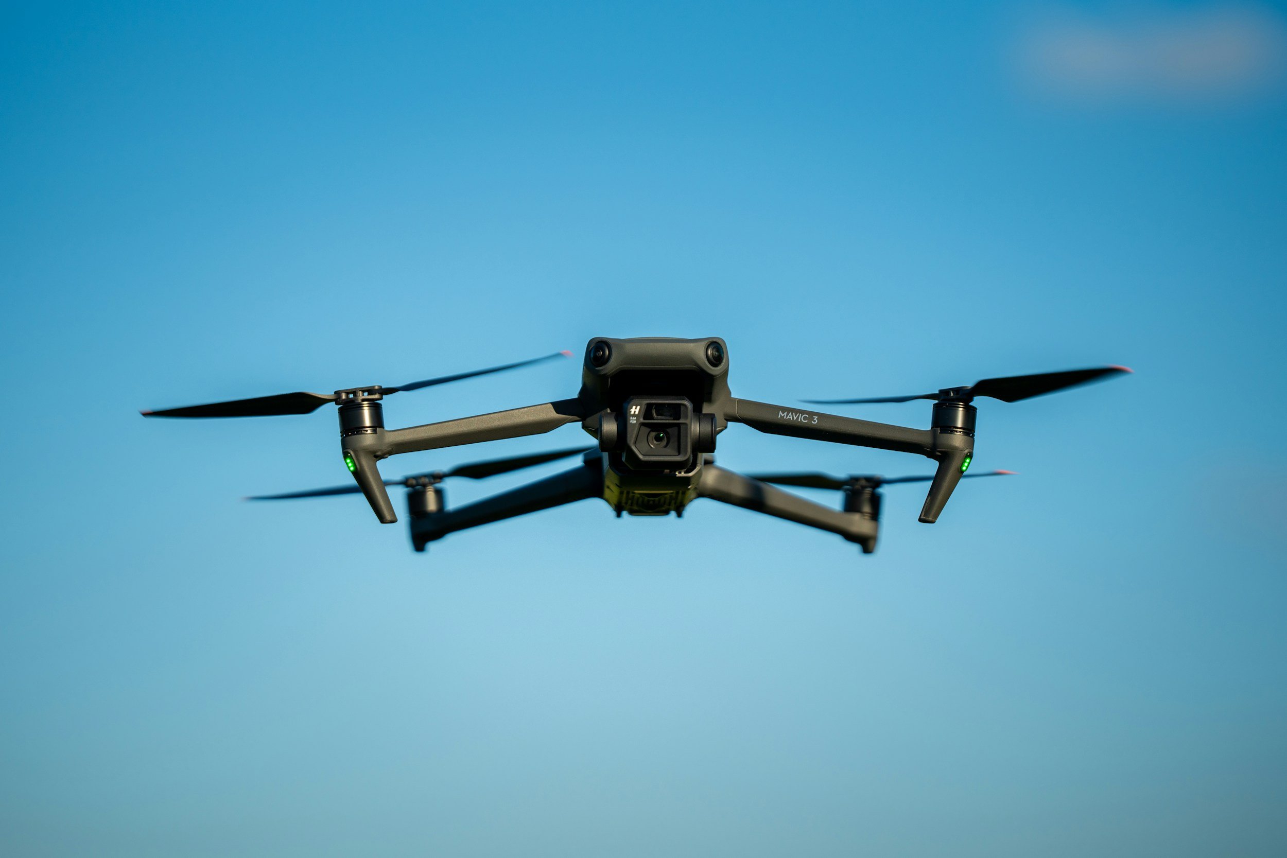 A drone flying in the clear blue sky.